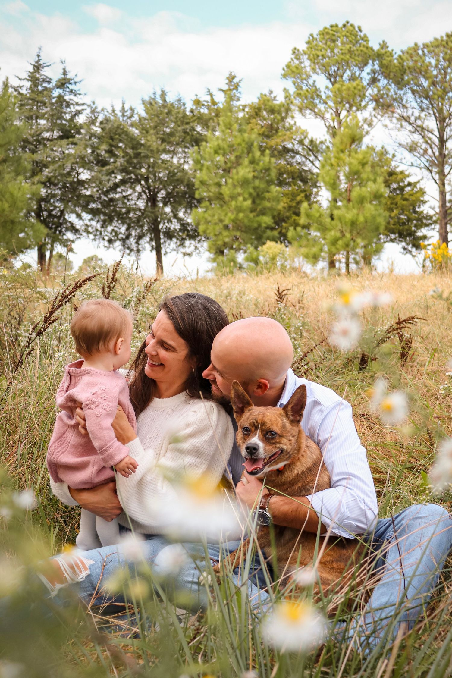 Candid lifestyle family session with three people and their dog, photographed in natural light.