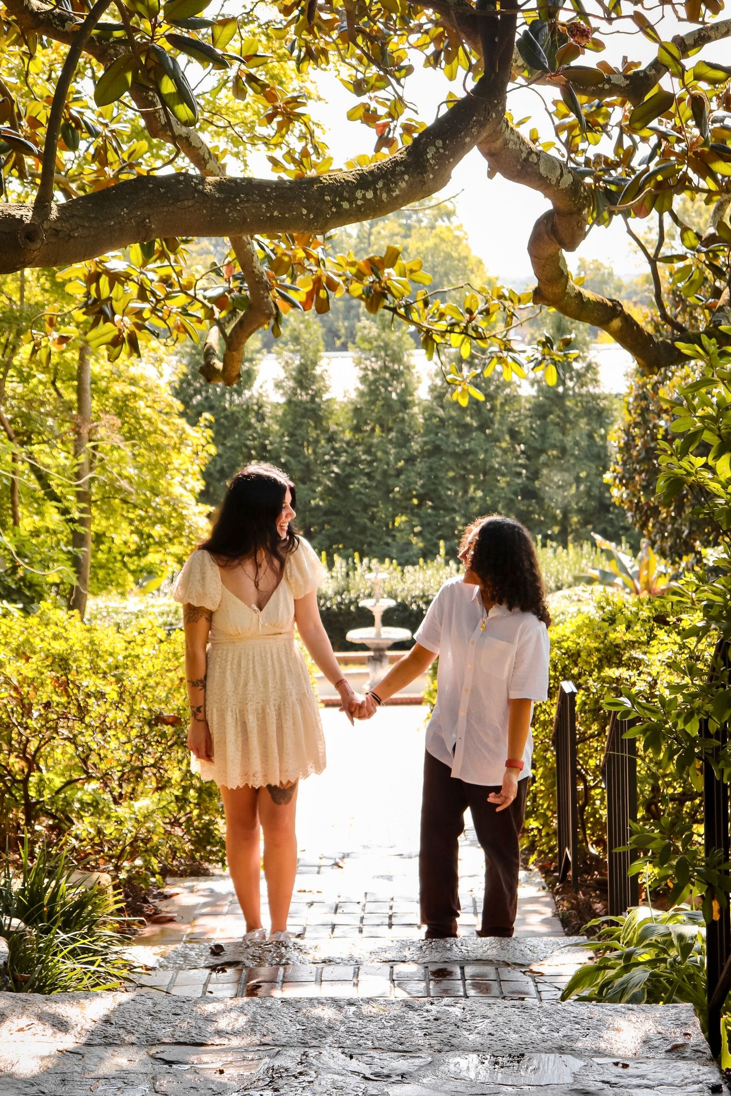 Sweet candid portrait of two girls holding hands looking at each other in warm lighting