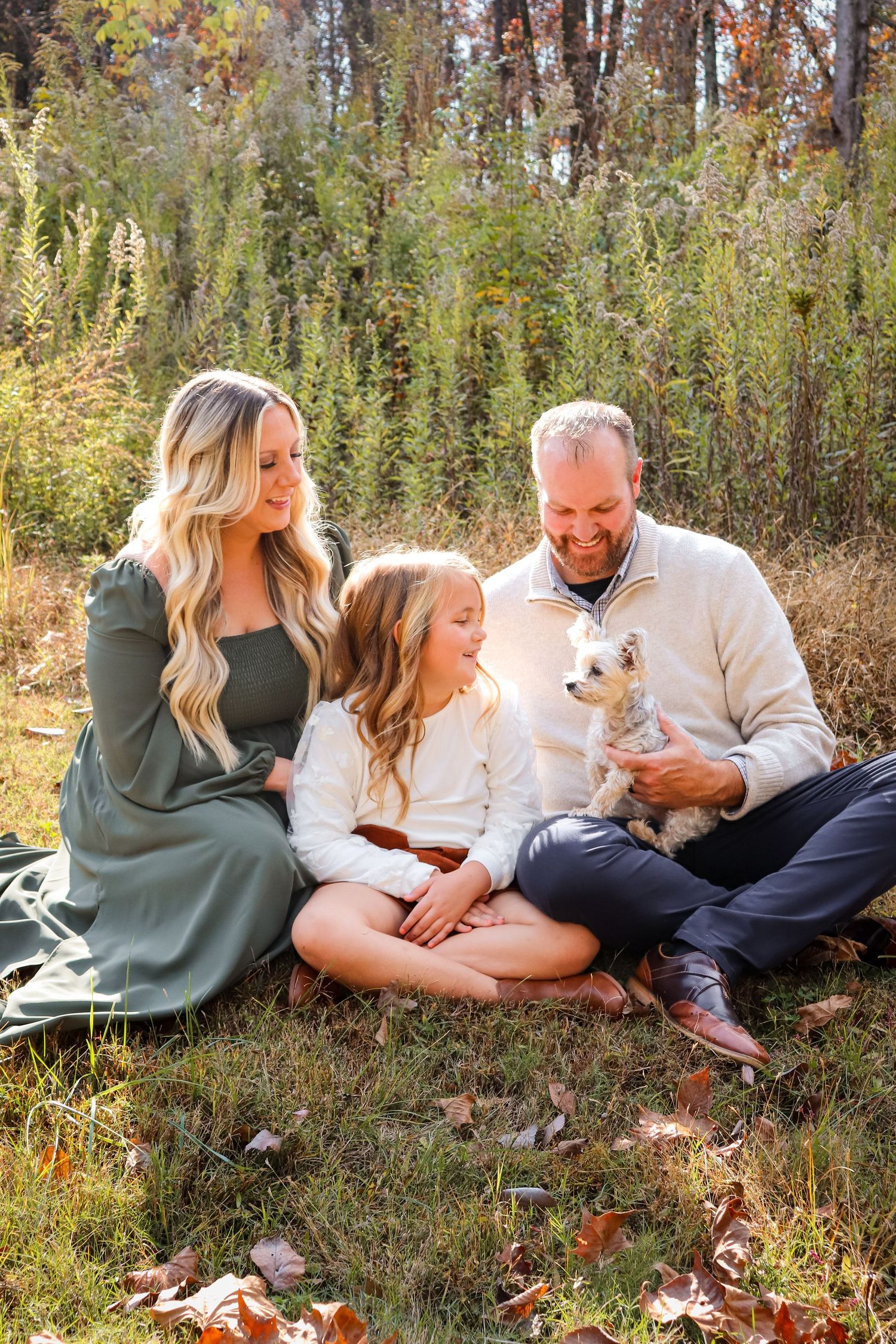 Lifestyle family session with three people and their dog, photographed in natural light.