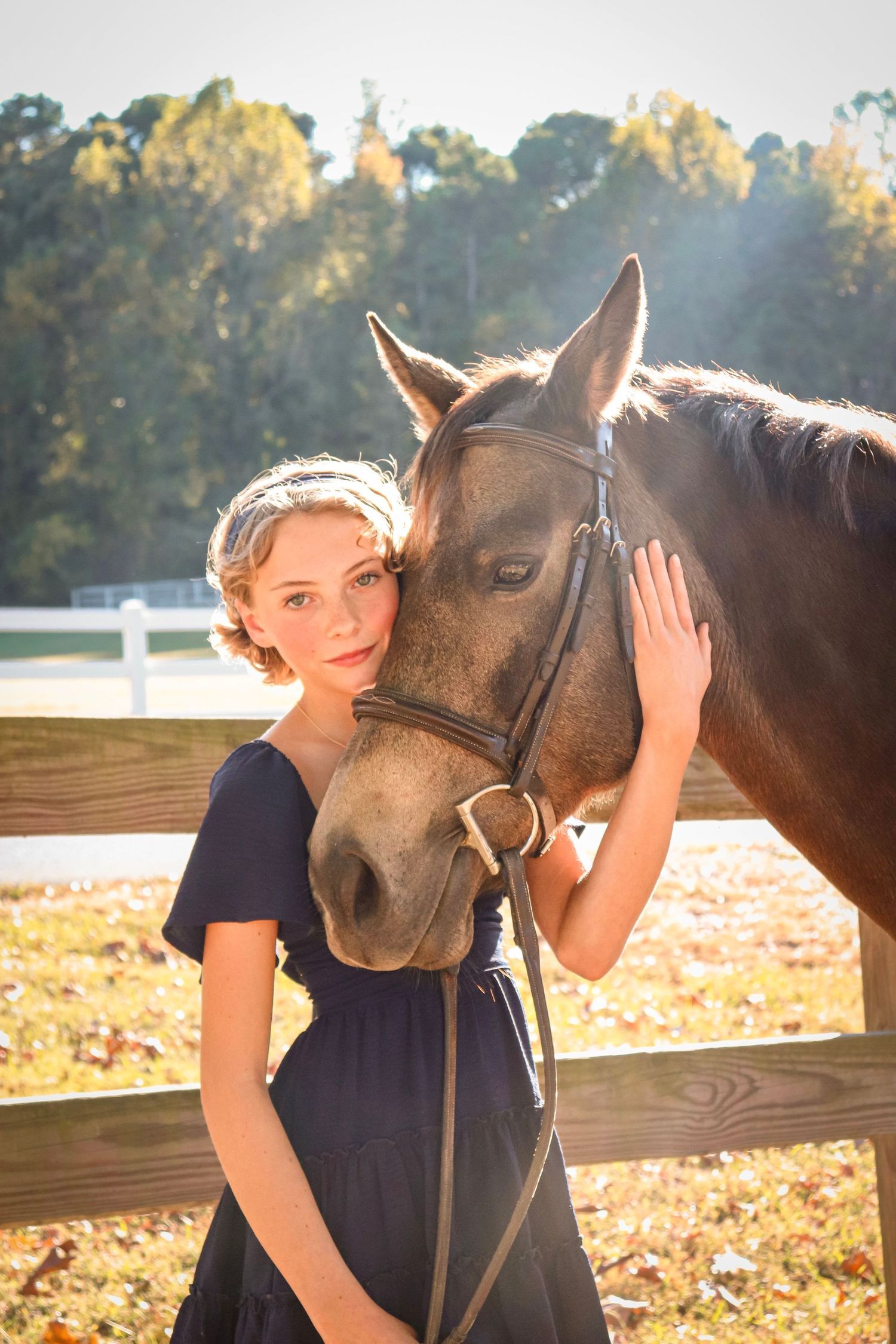 Portrait of a girl and her horse, taken outdoors in warm natural light.