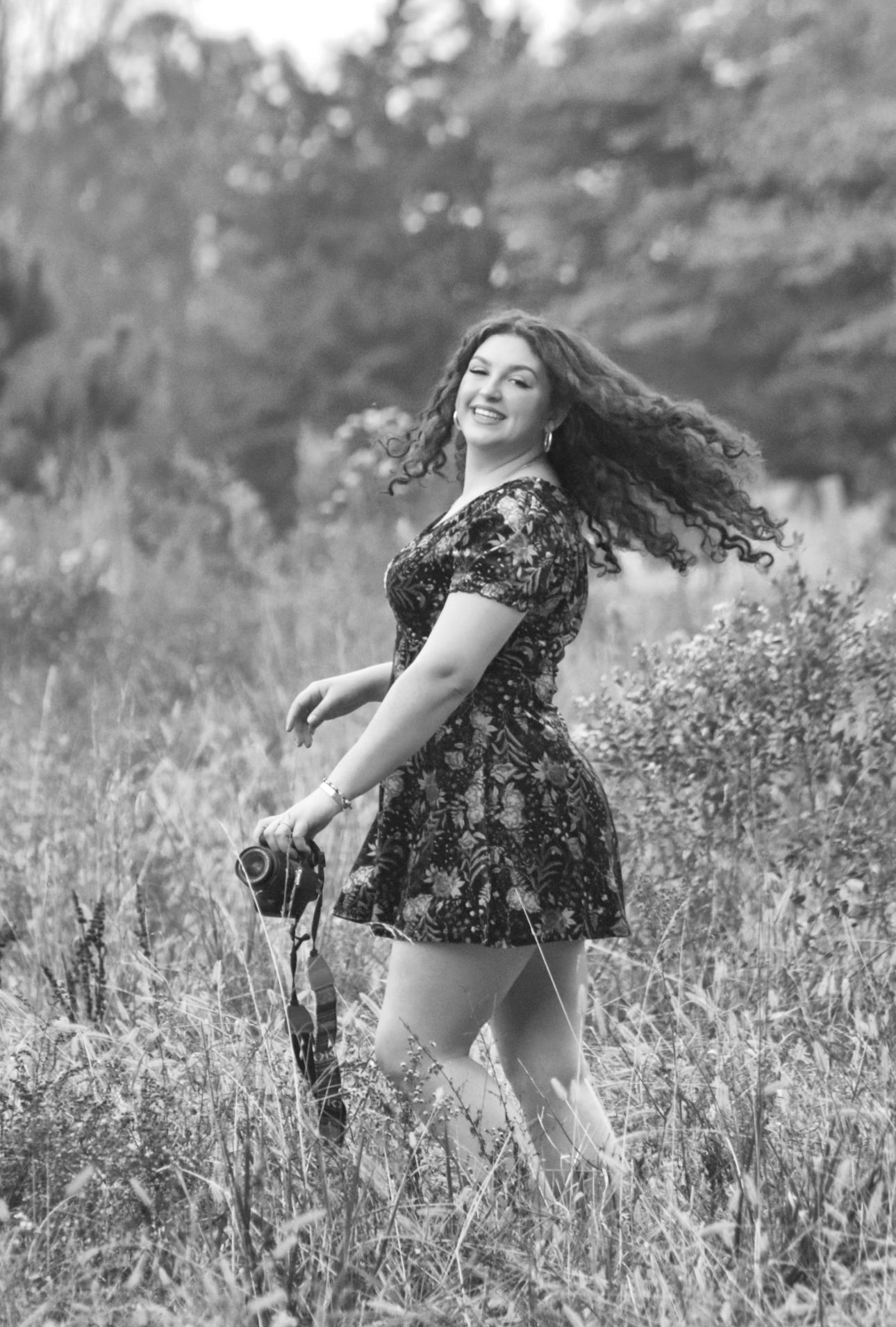 Creative portrait of a girl spinning with her camera, captured in a candid, playful style