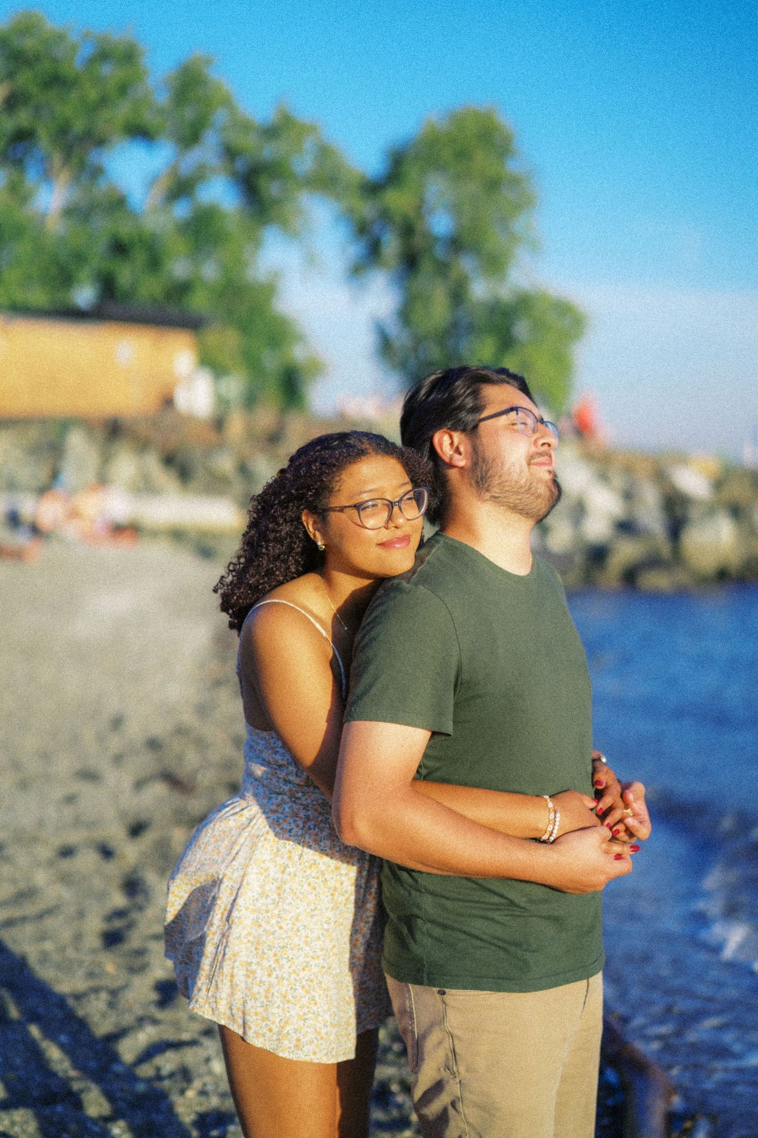Couple embracing by the water at sunset after a Seattle proposal, engagement photos