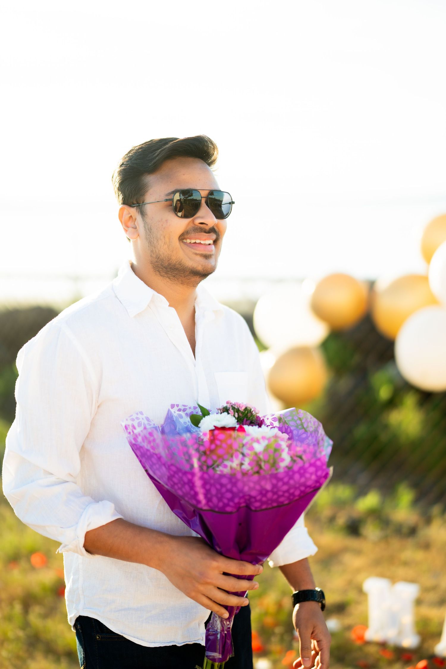 He waits in the meadow holding the bouquet, West Point Lighthouse proposal photographer, Discovery Park