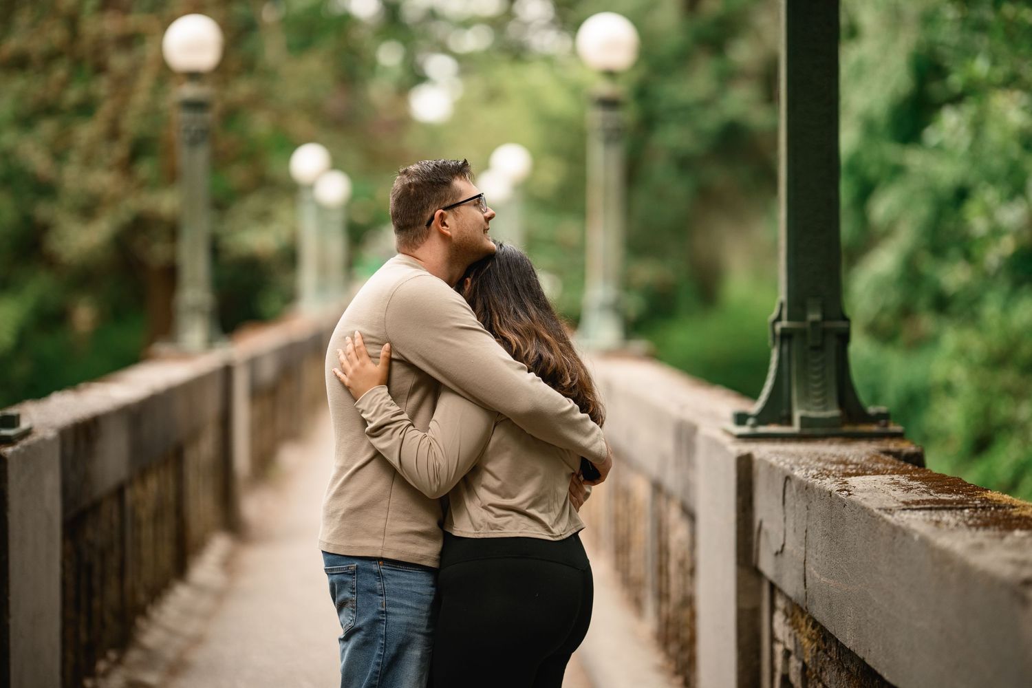 Newly engaged couple holding each other on the Wilcox Footbridge, Washington Park Arboretum proposal photographer, Seattle