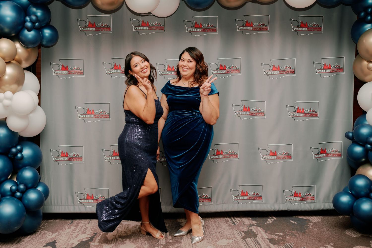 Two guests laughing at the step and repeat backdrop, awards gala photographer near Seattle, Renton