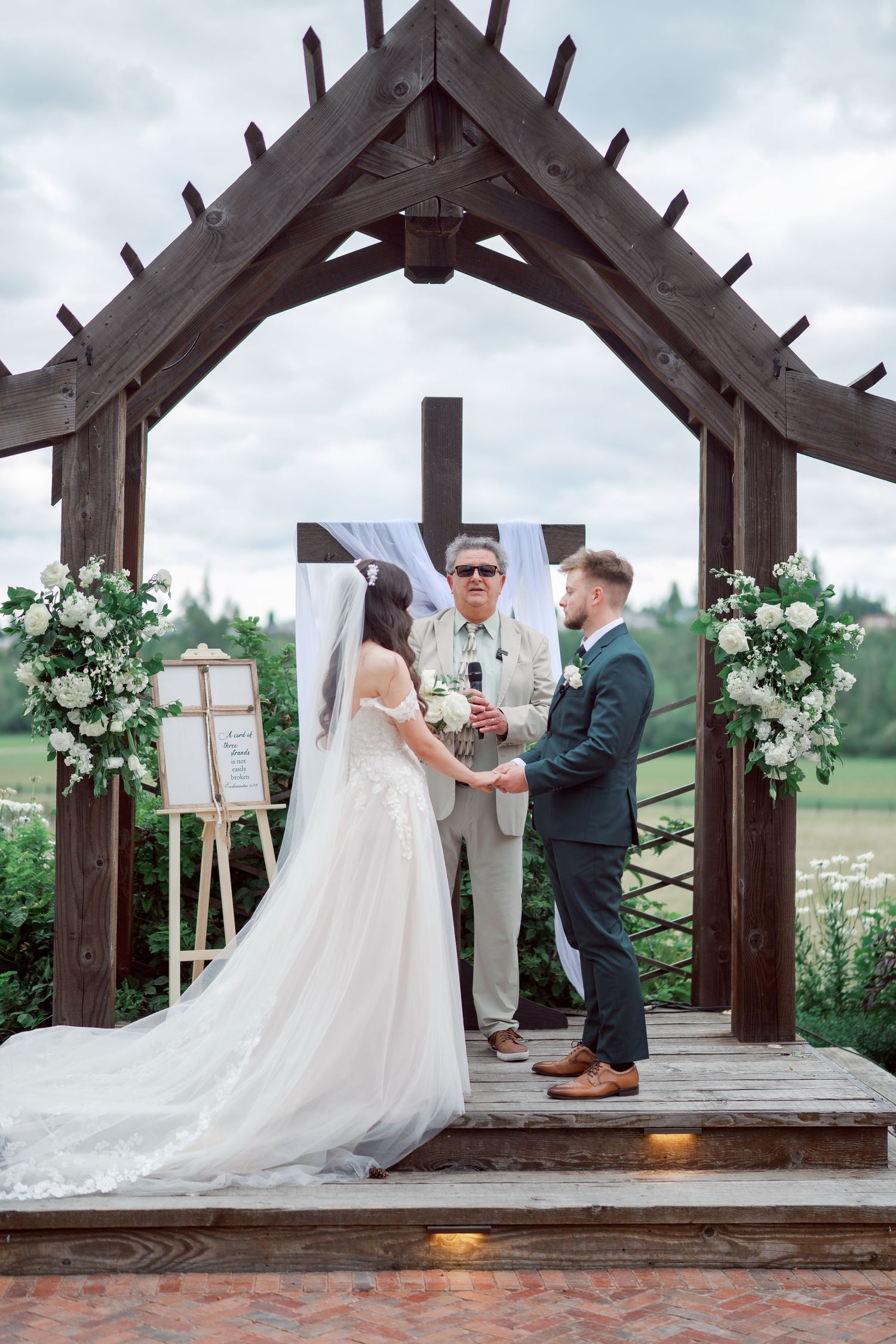 Bride and groom exchange vows at the wooden arch, Kelley Farm wedding in Bonney Lake