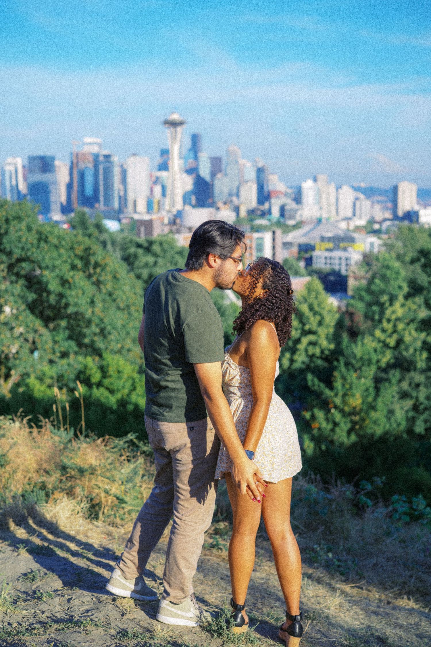 Newly engaged couple embracing with the Seattle skyline behind them, Kerry Park proposal photographer