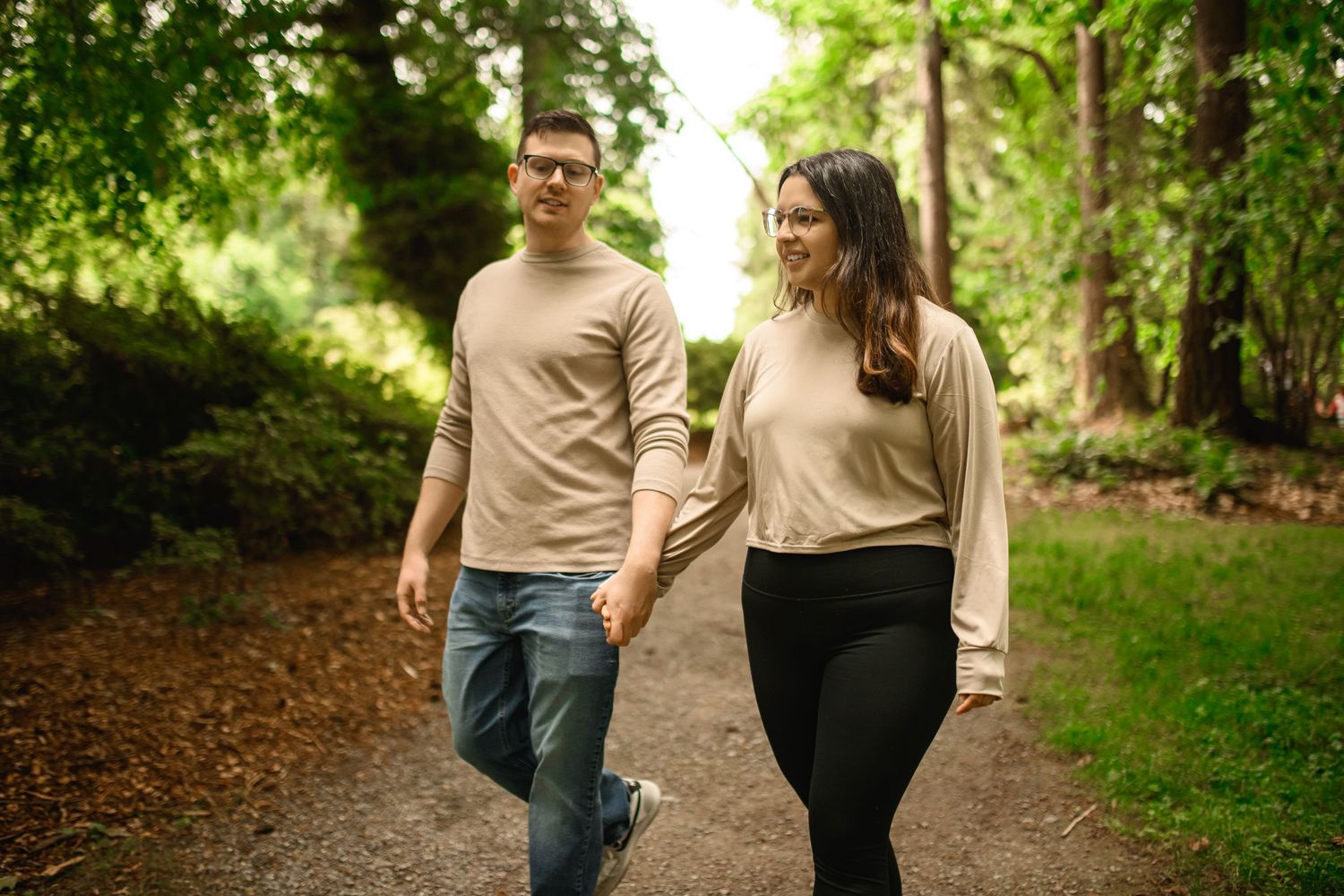 Couple walking a shaded gravel trail before the proposal, Washington Park Arboretum proposal photographer, Seattle