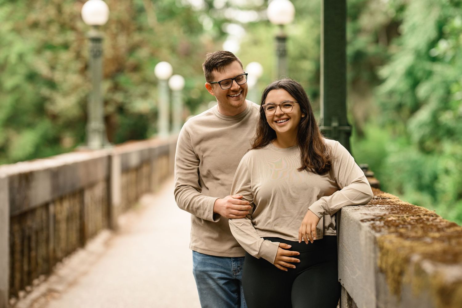 Engaged couple leaning on the bridge wall with the globe lamps behind, Washington Park Arboretum proposal photographer, Seattle