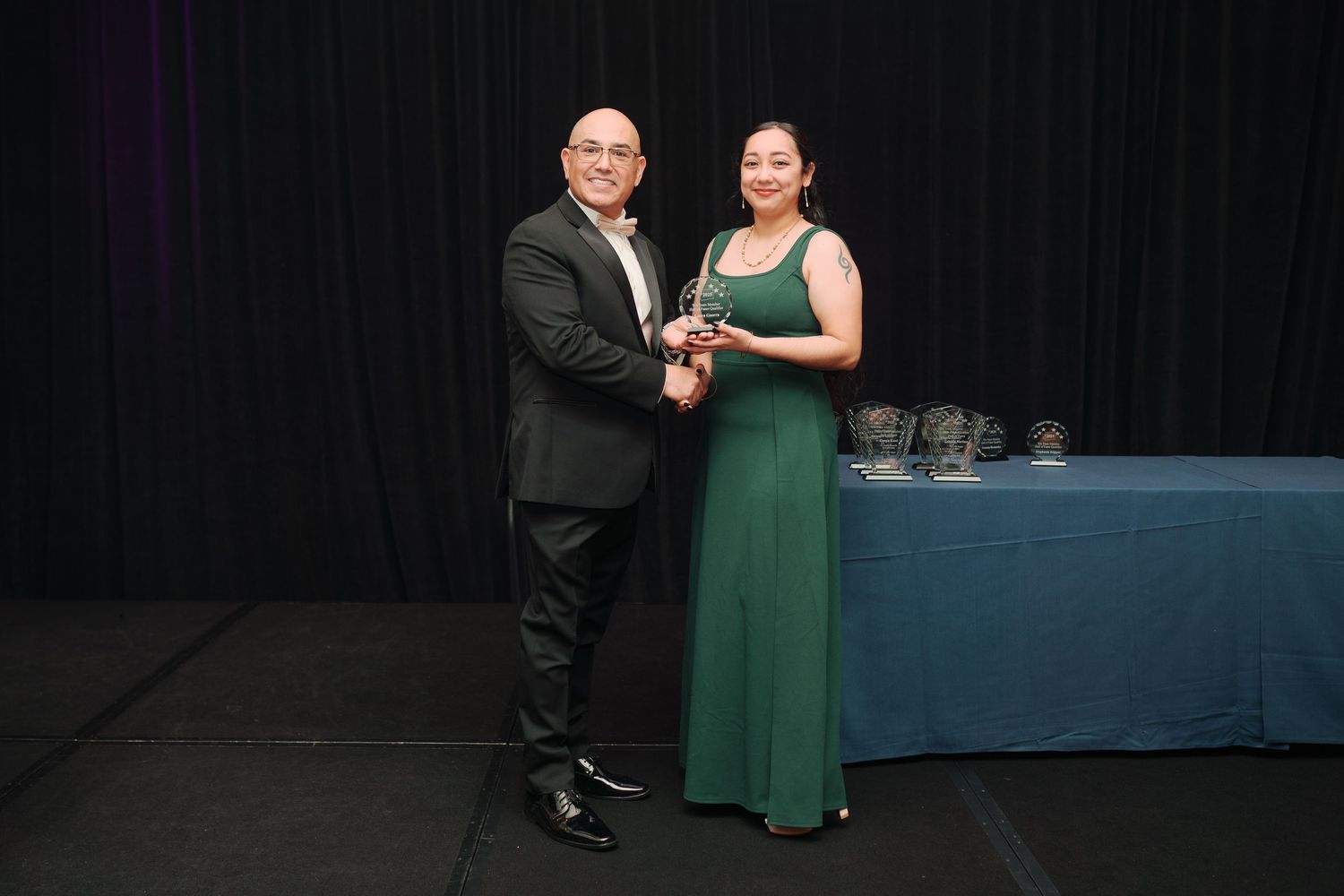 Award recipient in green with presenters, corporate awards night photographer, Renton Washington