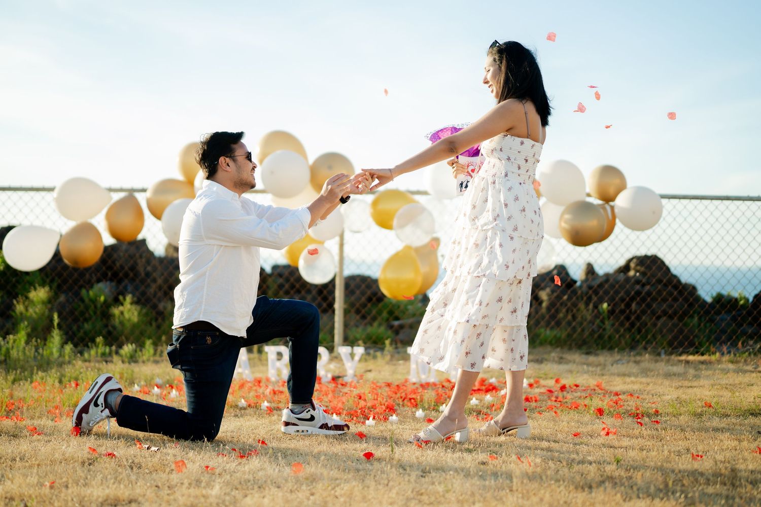 Her hands go up as he asks, West Point Lighthouse proposal photographer, Discovery Park