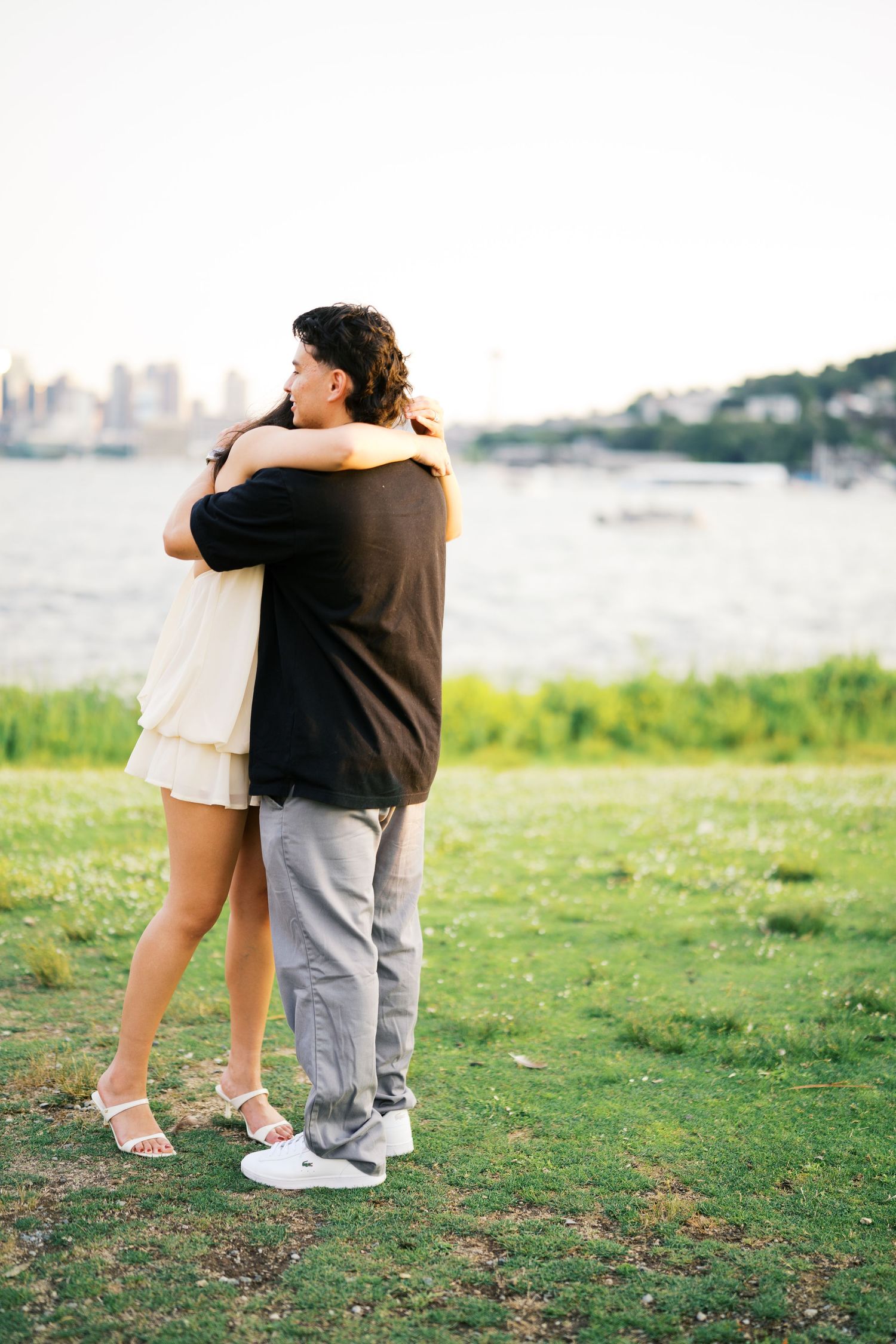 Newly engaged couple holding each other above Lake Union, Gas Works Park engagement photos Seattle