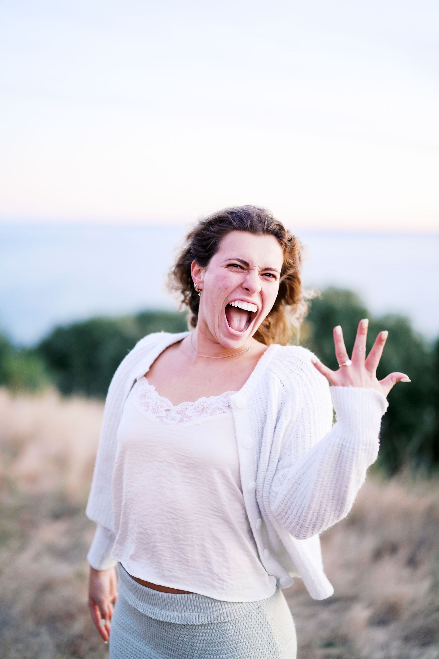 Celebrating in the grass after saying yes, Discovery Park proposal photographer, Seattle