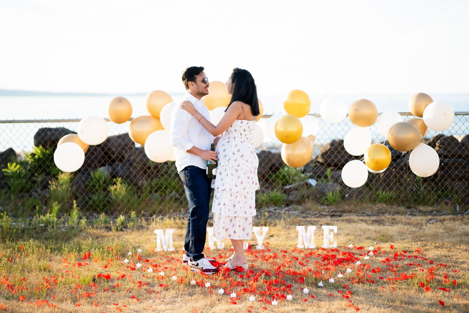 Kissing under the arch with MARRY ME at their feet, West Point Lighthouse proposal photographer, Discovery Park