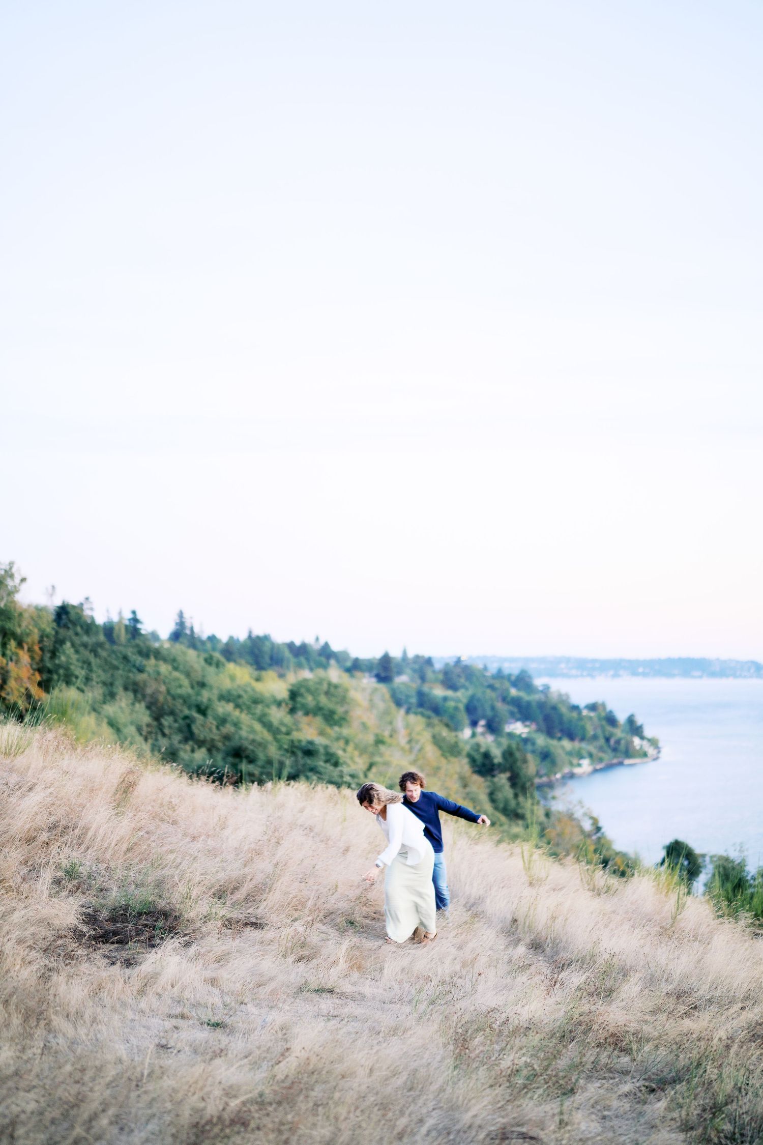 Walking up through the tall grass on the bluff, Discovery Park proposal photographer, Seattle