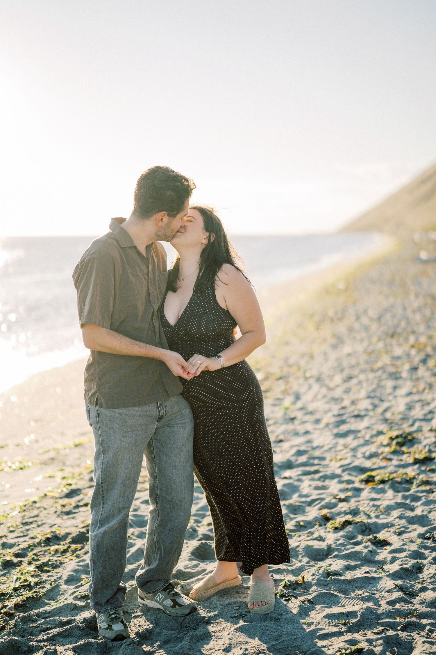 Couple kissing on the sand with the bluff behind them, Whidbey Island proposal photographer, Freeland
