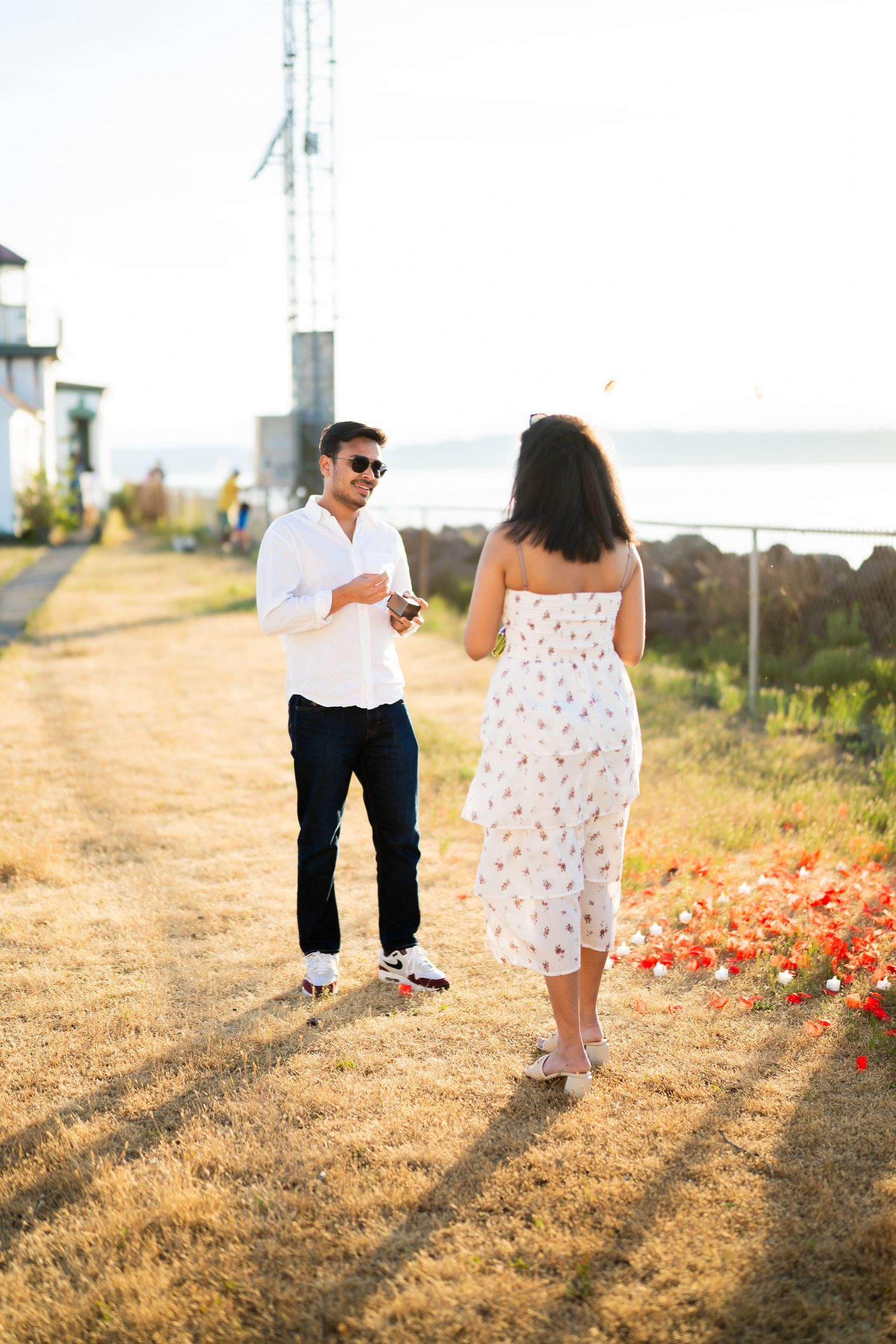 Walking down the meadow toward the setup, West Point Lighthouse proposal photographer, Seattle