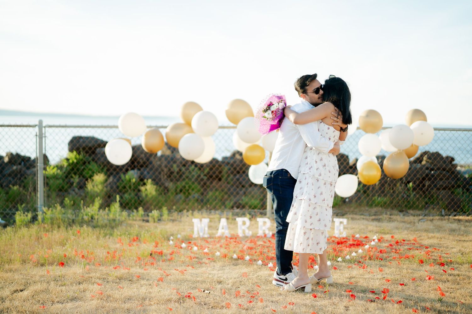 Holding each other in the meadow after the proposal, proposal photographer at West Point Lighthouse, Discovery Park Seattle