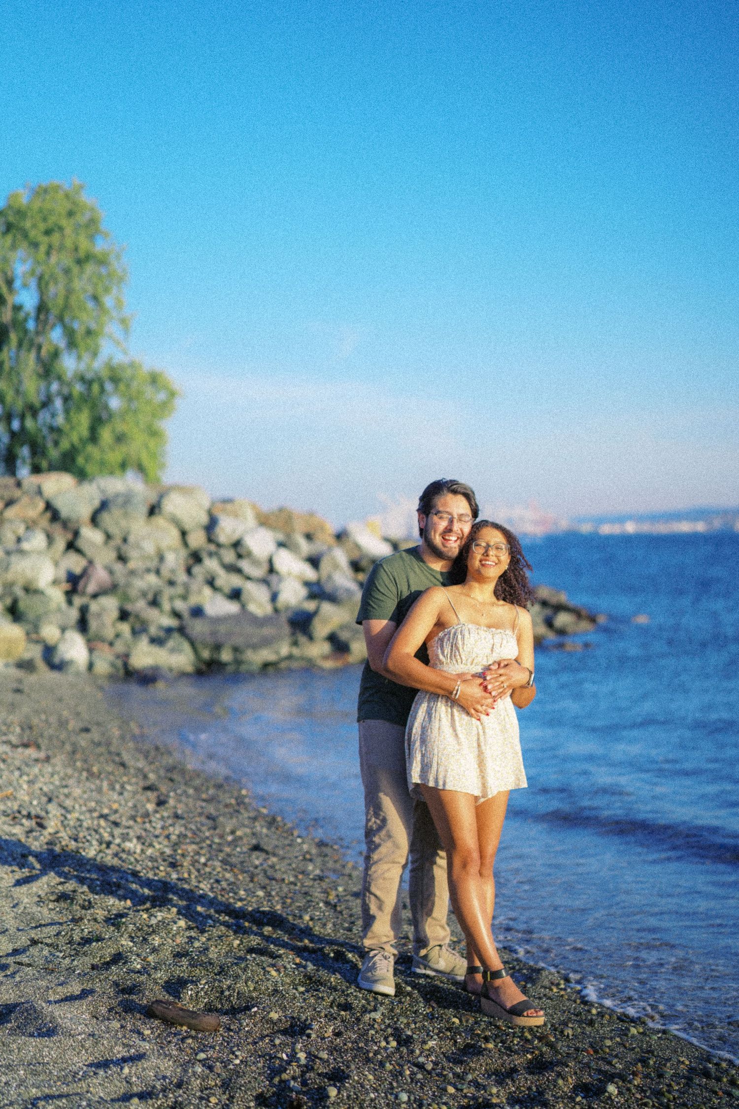 Couple on the rocky shoreline after their Seattle proposal, engagement photos