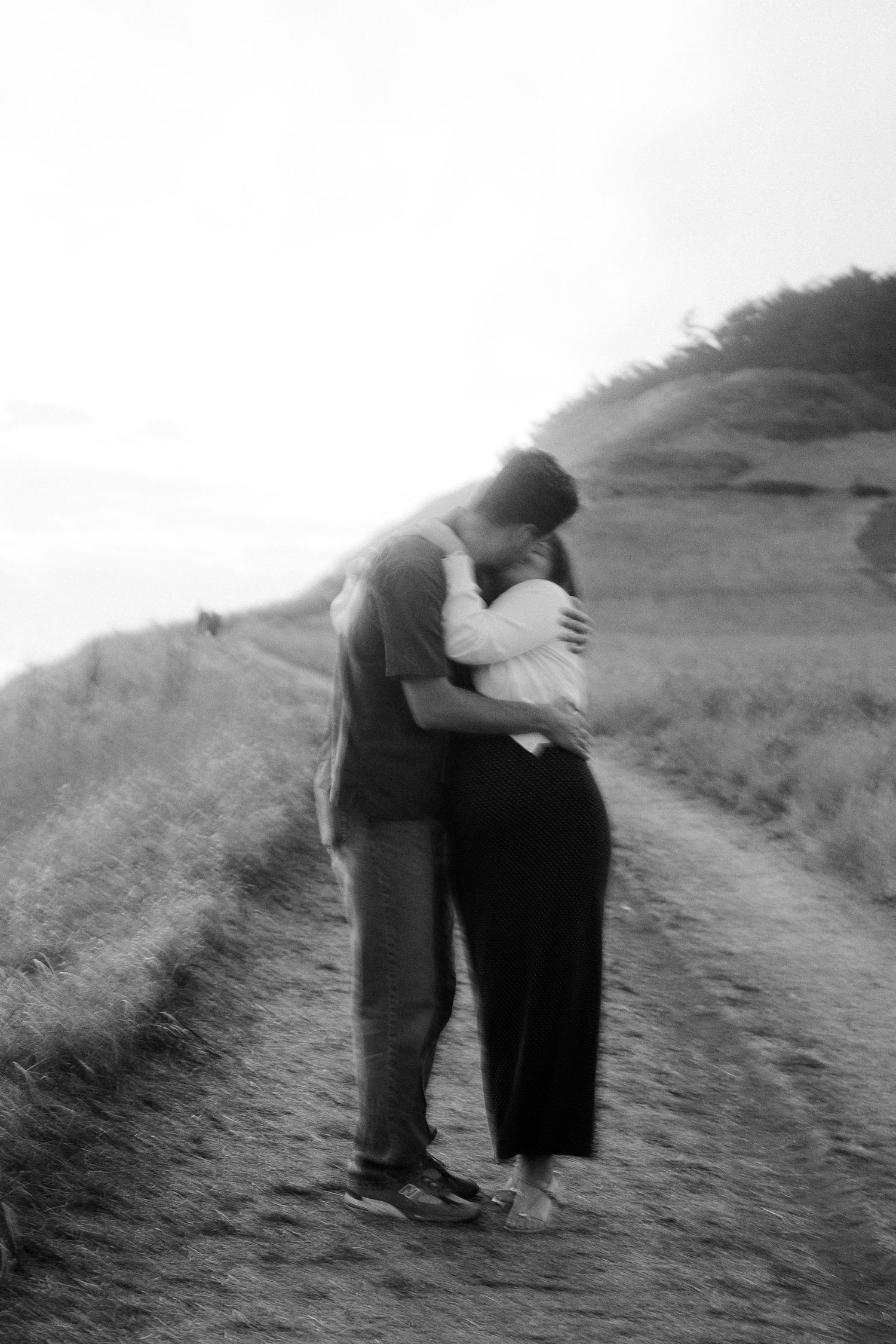 Black and white of the couple holding each other on the bluff path, Whidbey Island proposal photographer, Freeland