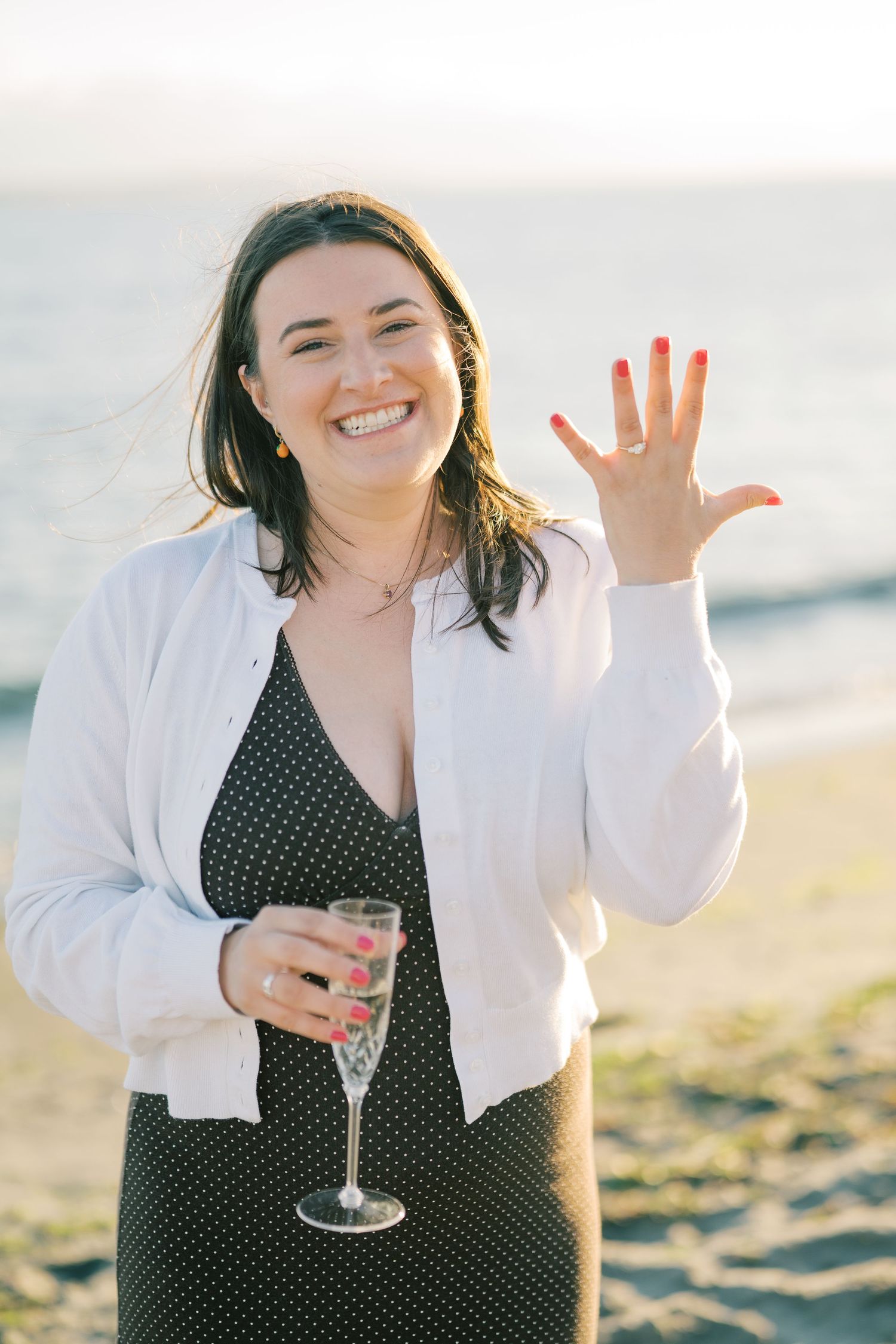 She laughs and shows the ring with champagne in hand, Whidbey Island proposal photographer, Whidbey Island