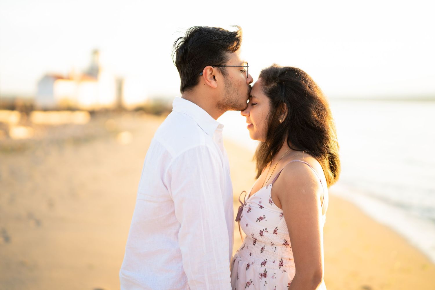 Foreheads together on the sand in the last of the sun, West Point Lighthouse proposal photographer, Seattle
