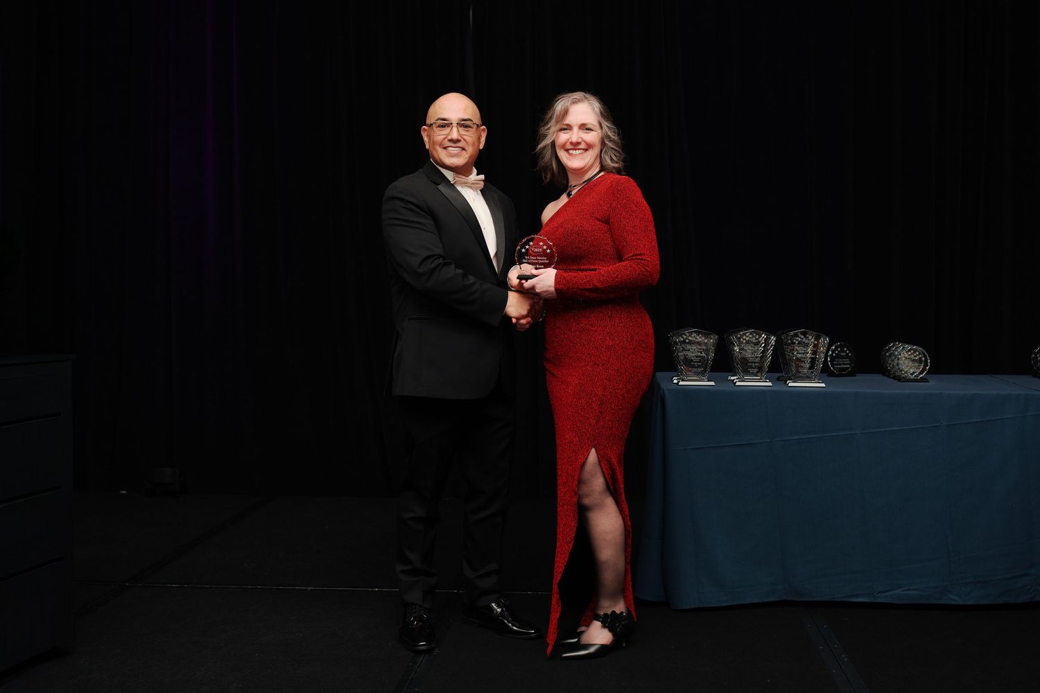 Award presented on stage to a recipient in red, gala awards photography at the Hyatt Regency Lake Washington