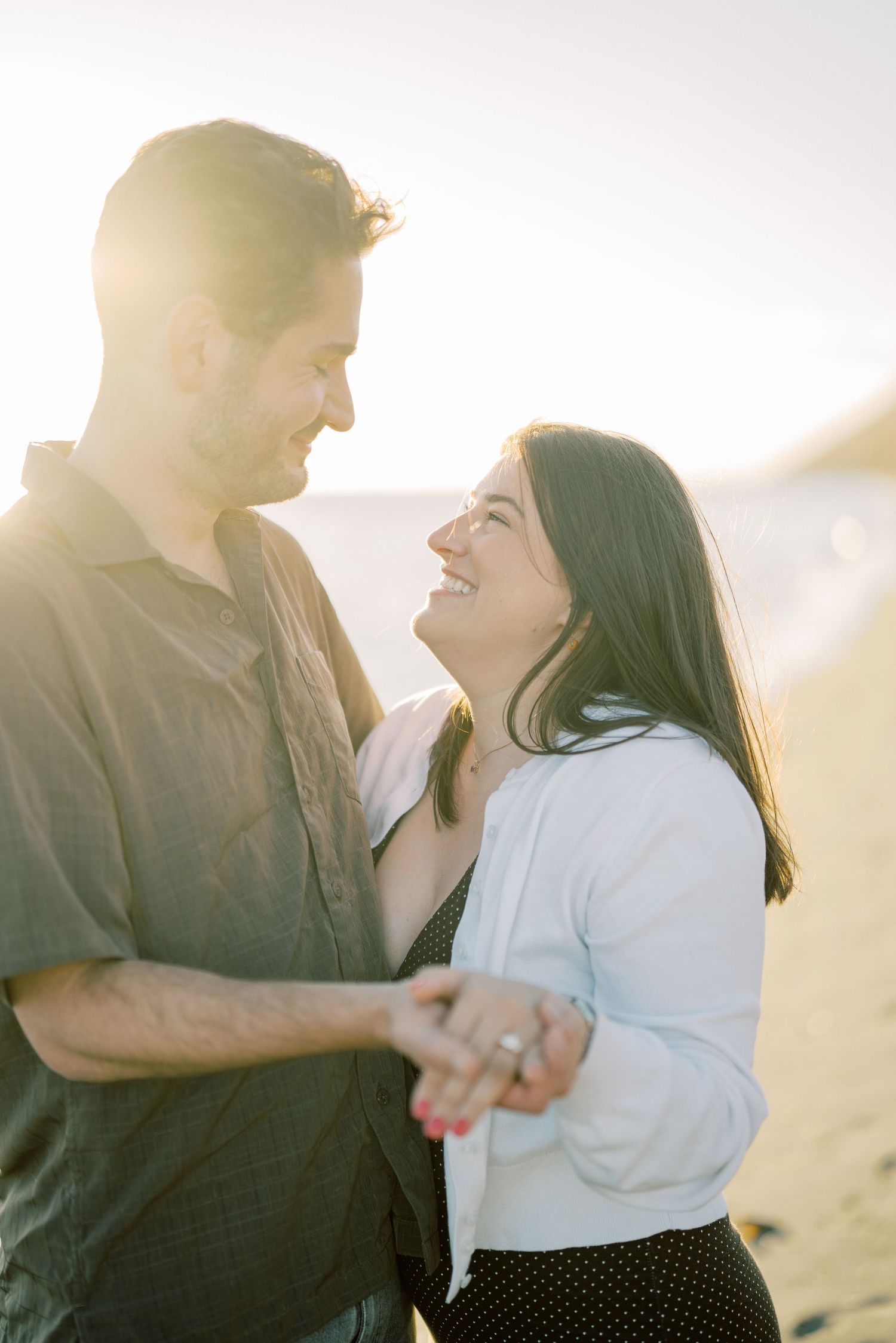 Newly engaged couple laughing together in the backlit evening sun, Whidbey Island proposal photographer, Freeland