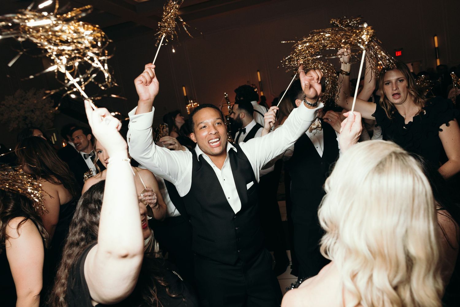Energetic wedding reception celebration with sparklers and dancing.