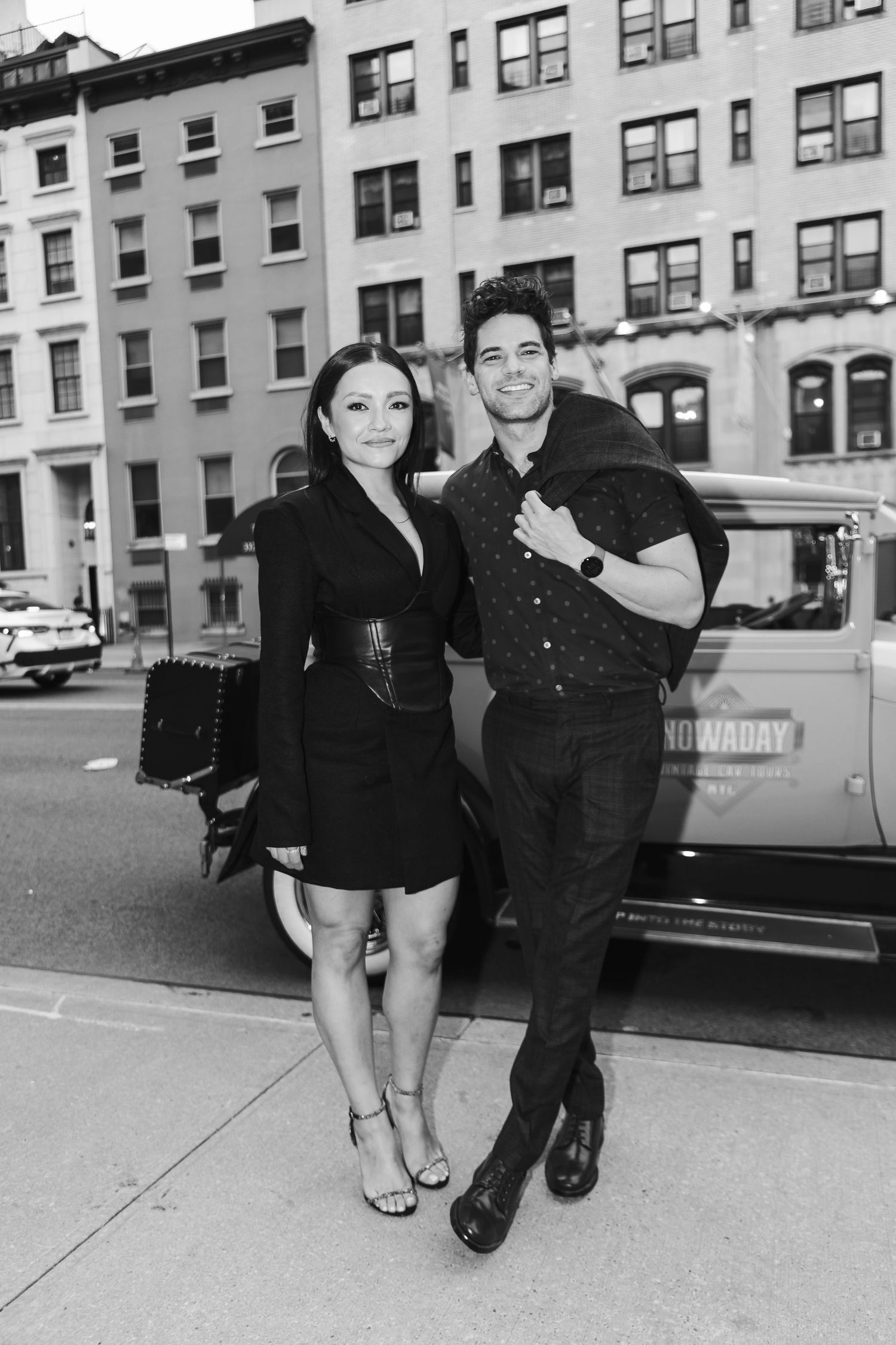 Vintage black and white photo of people posing playfully on a city street.