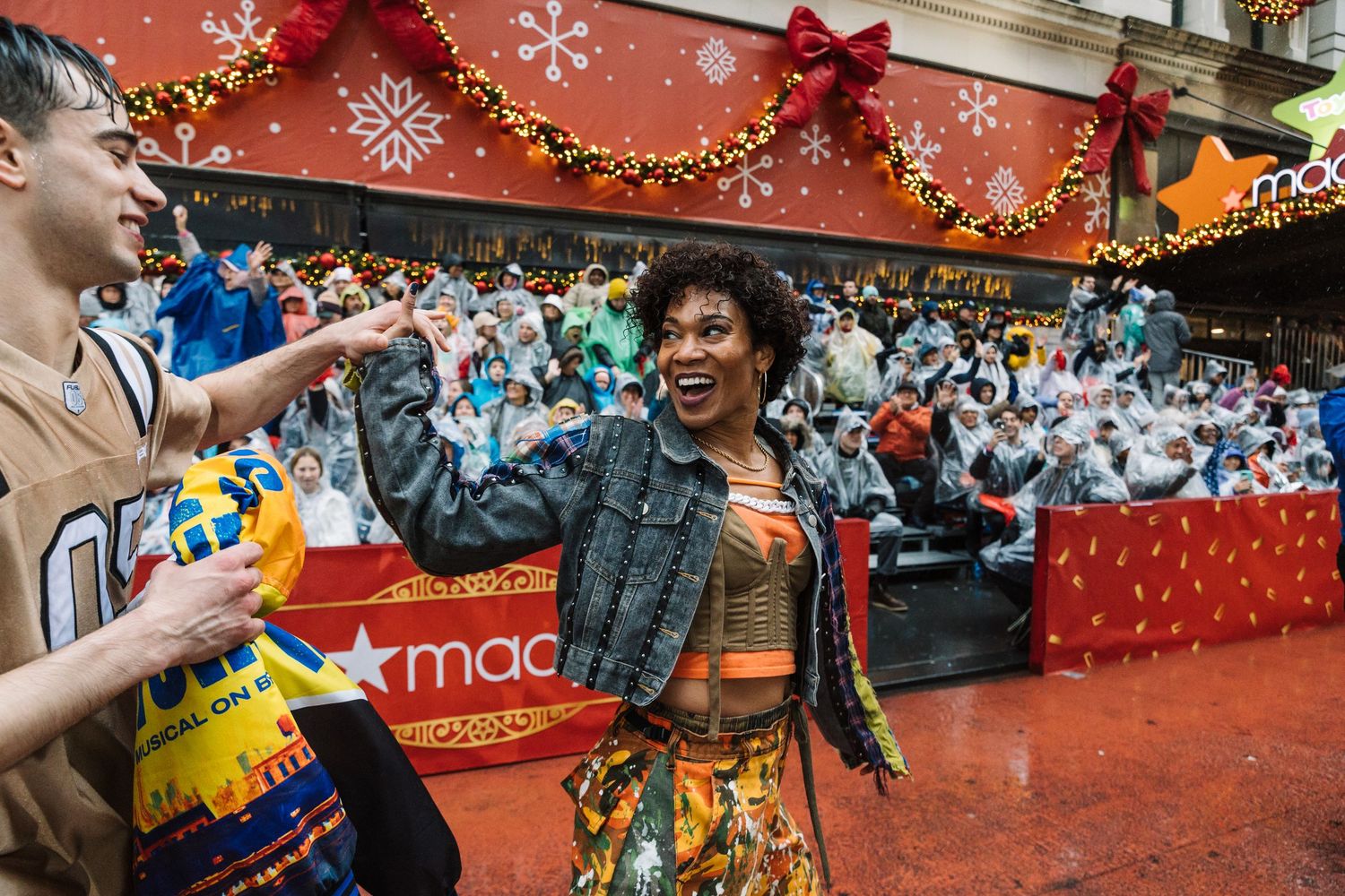 Joyful celebration during street festival with holiday decorations and crowd in background.