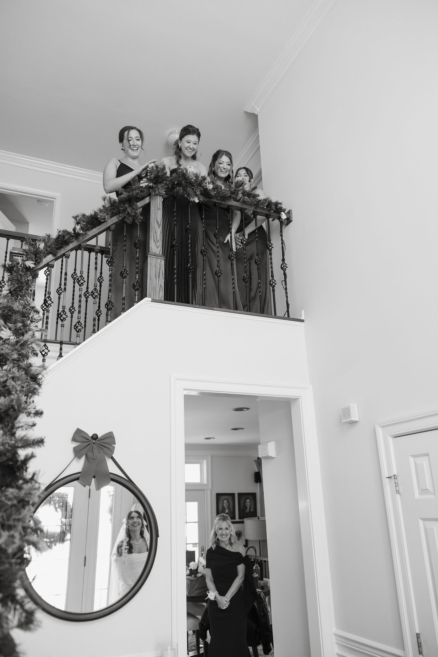 A series of black and white photos showing people standing on an indoor balcony overlooking a white interior space.