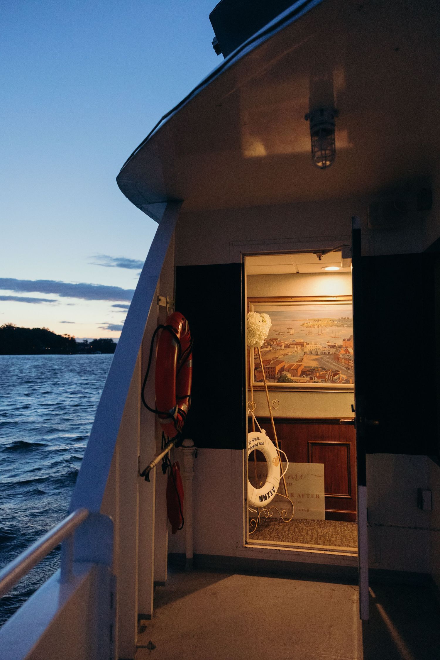 Evening views from a boat deck showing illuminated cabin interior and ocean waves.