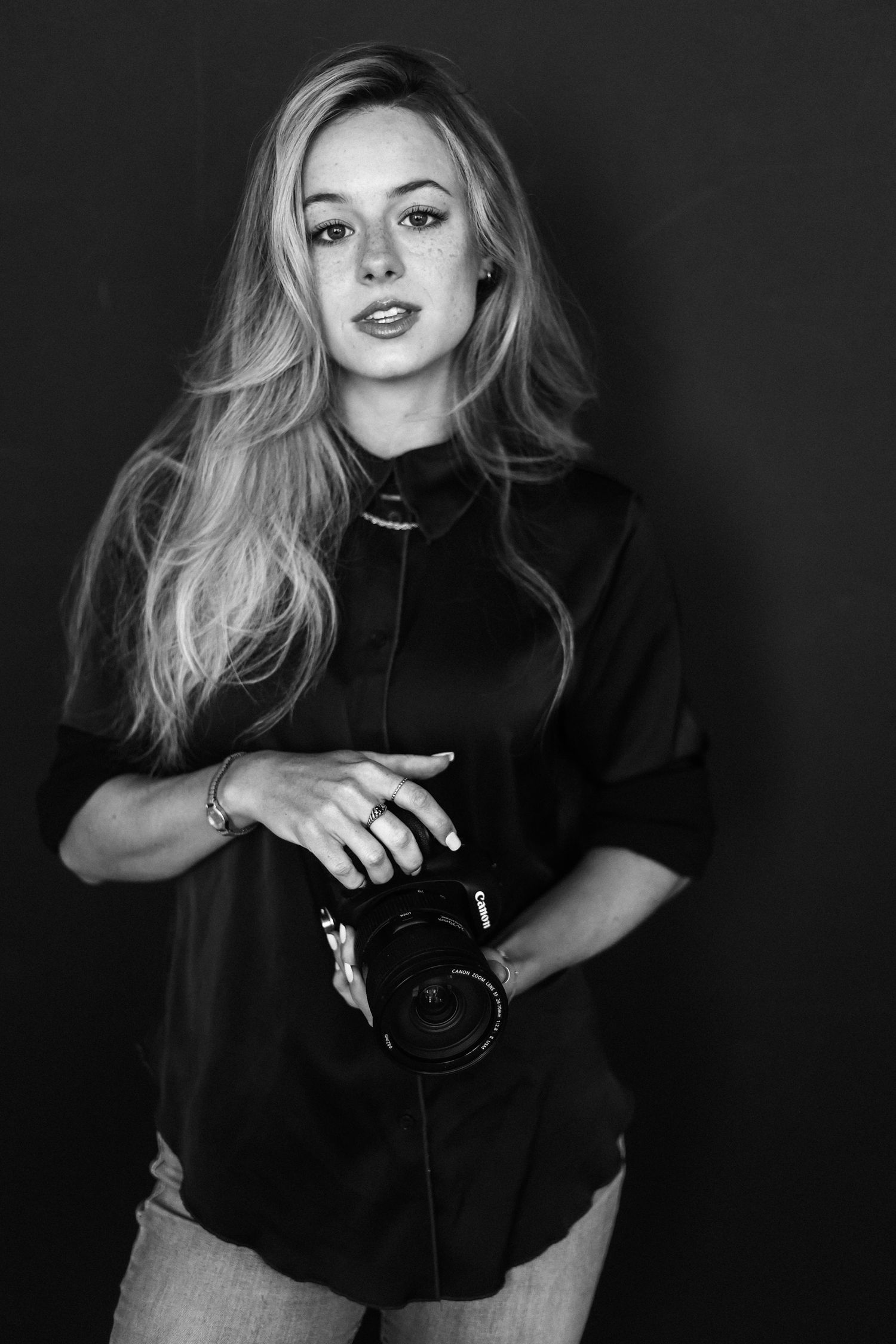 Dramatic black and white portrait series featuring artistic poses with a camera.
