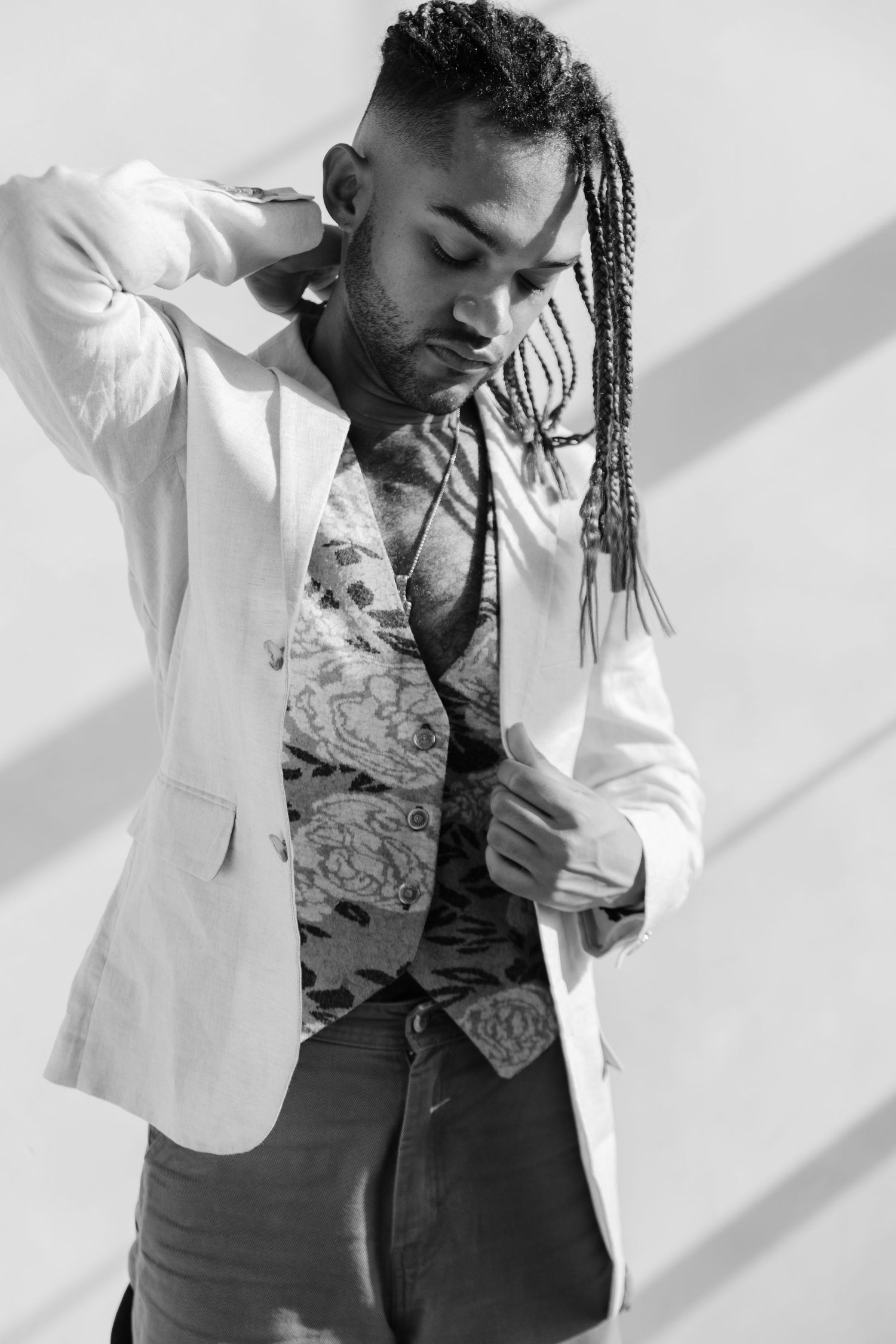 Portrait series showing artistic poses in formal attire with dramatic lighting and shadows of Brandon Cameron from Hadestown Broadway