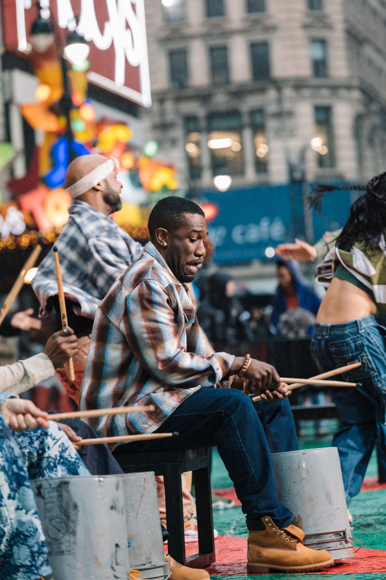 Musicians performing with drumsticks during outdoor street festival.