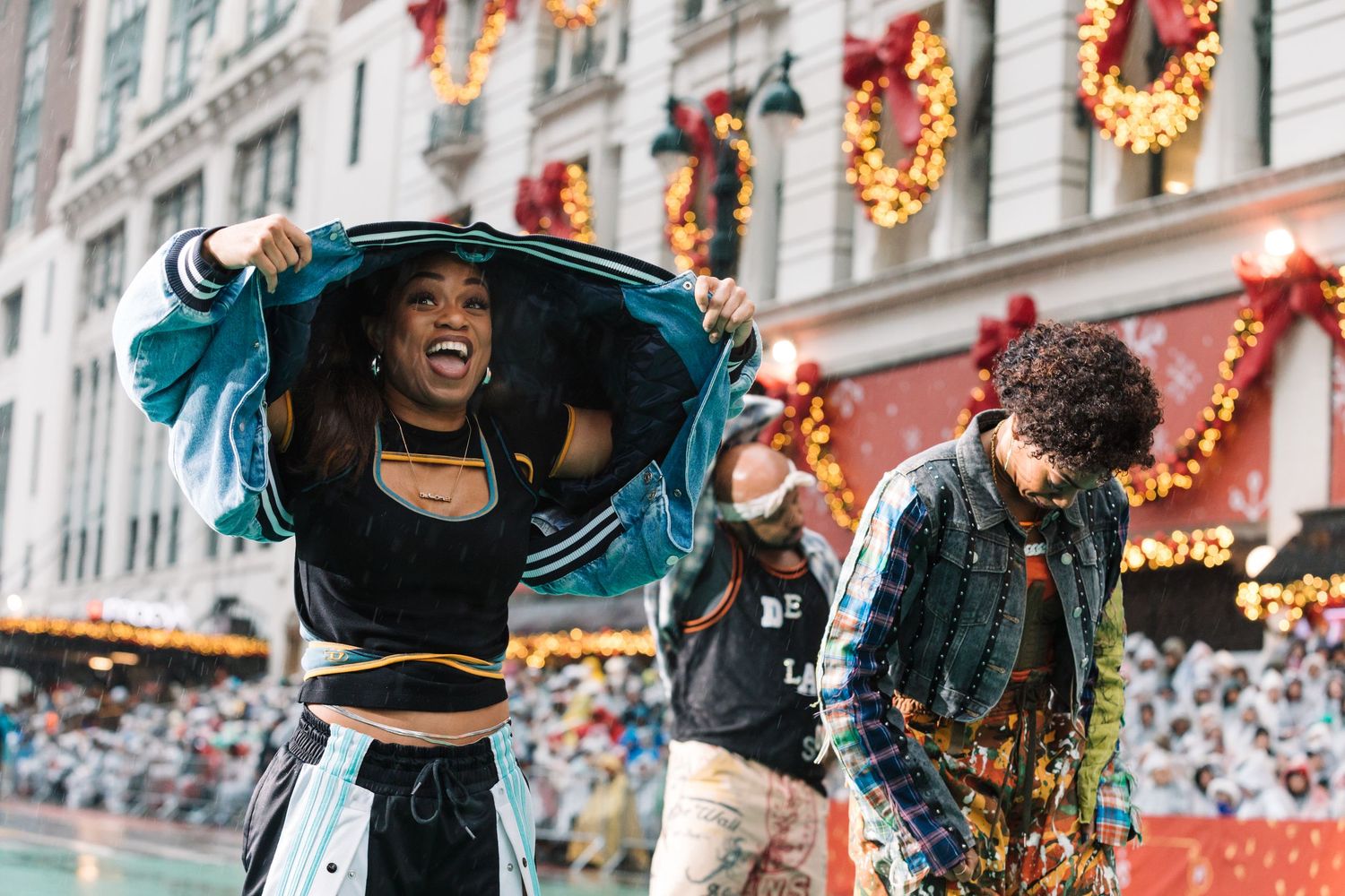 Energetic dance performance during street festival with decorated building facade.