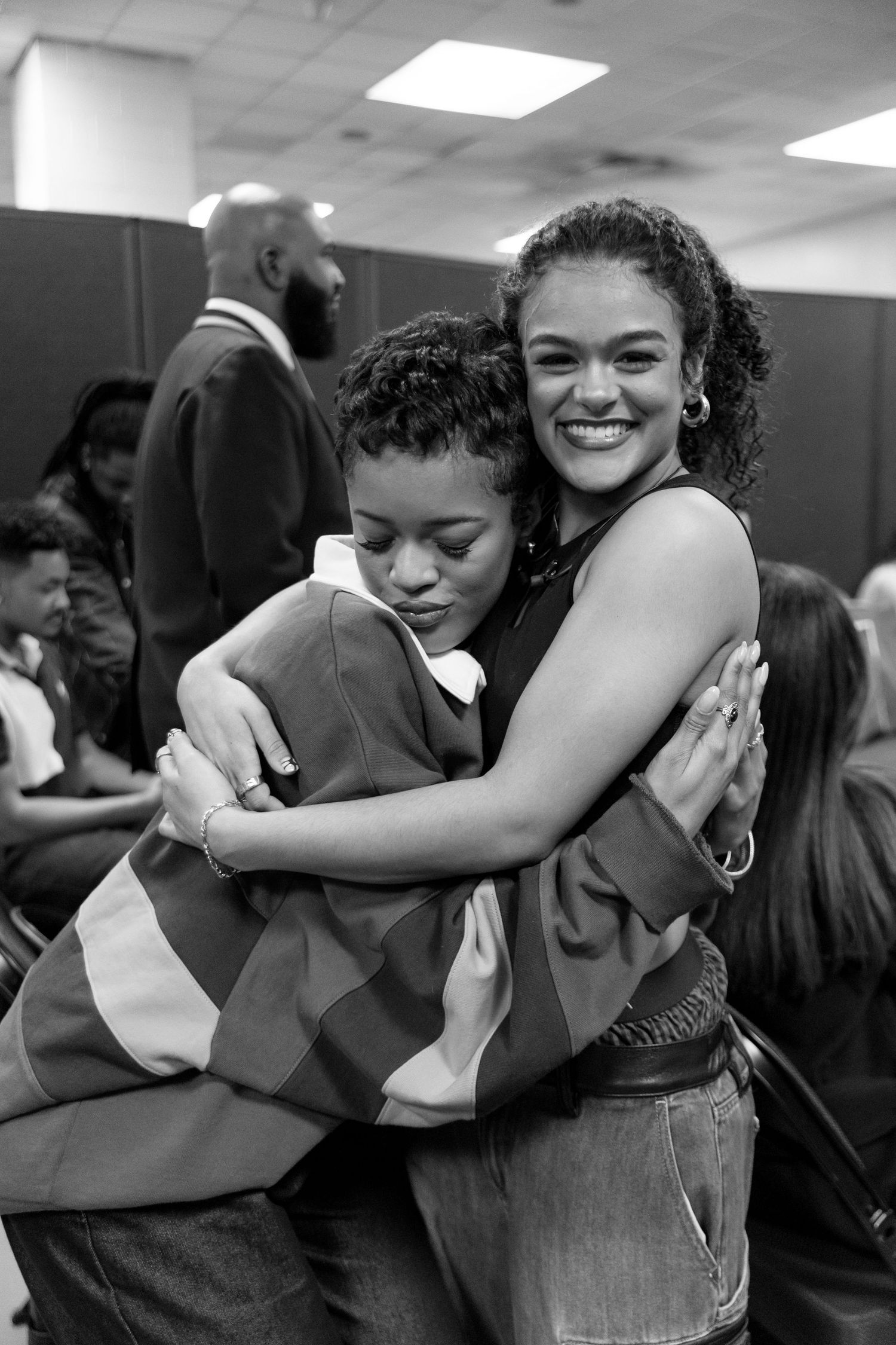 People share joyful embraces in black and white photo.