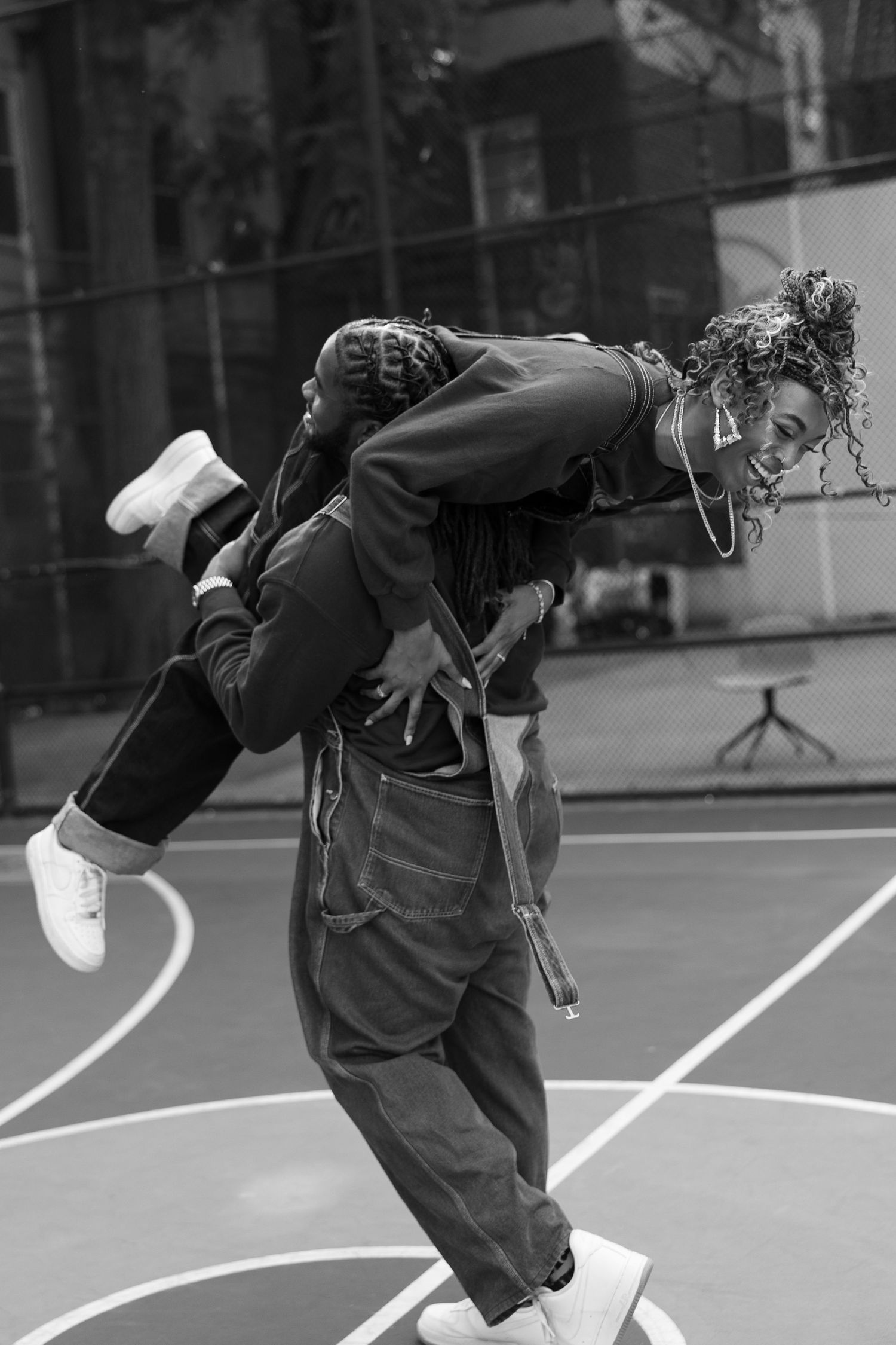 Dynamic dance movements captured in black and white on a basketball court.