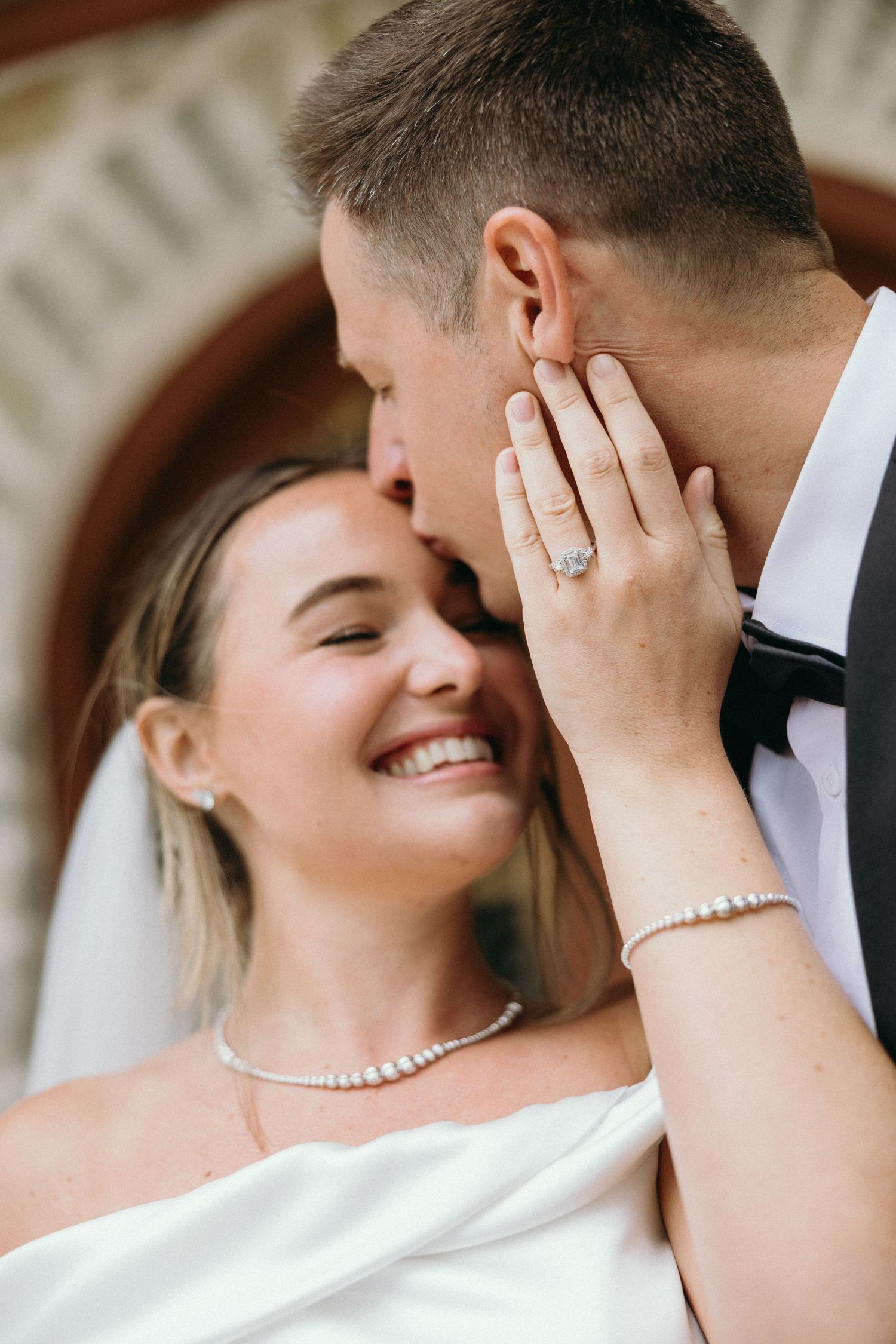 Close-up intimate moment between couple in formal wedding attire.