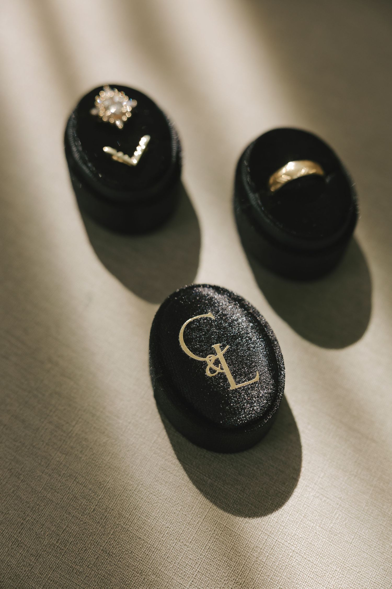 Wedding rings casting dramatic shadows on a textured linen surface in black and white.