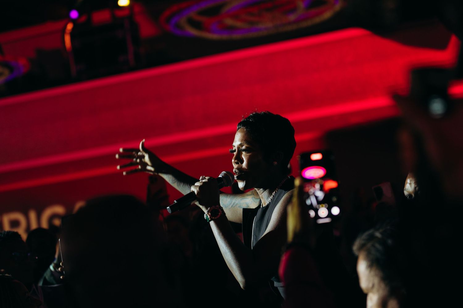 Tiwa Savage stands on stage at UNSTOPPABLE AFRICA United Nations, dramatic red lighting and fog effects during a live concert performance.