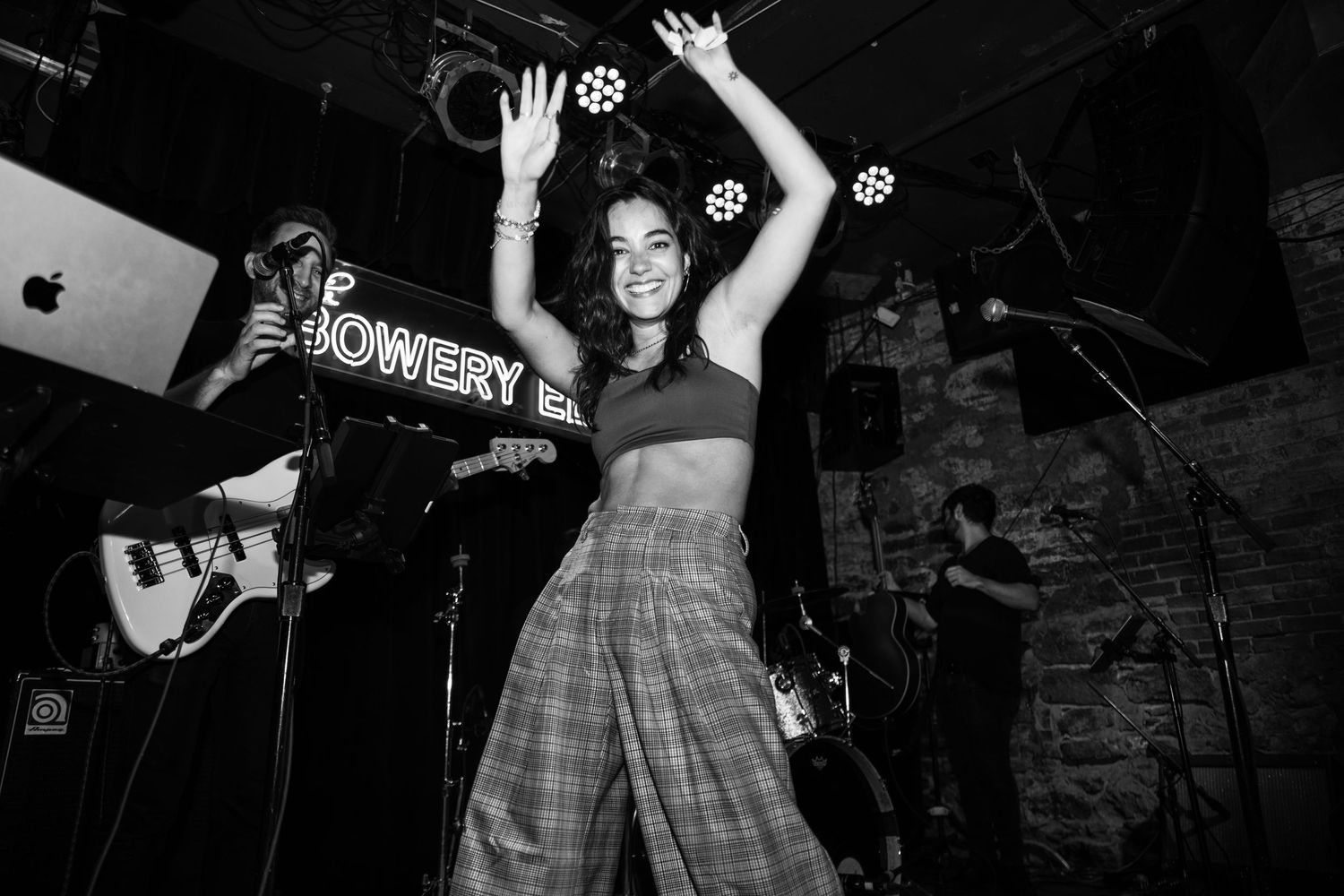 Live music performance in a dimly lit venue with dramatic stage lighting.