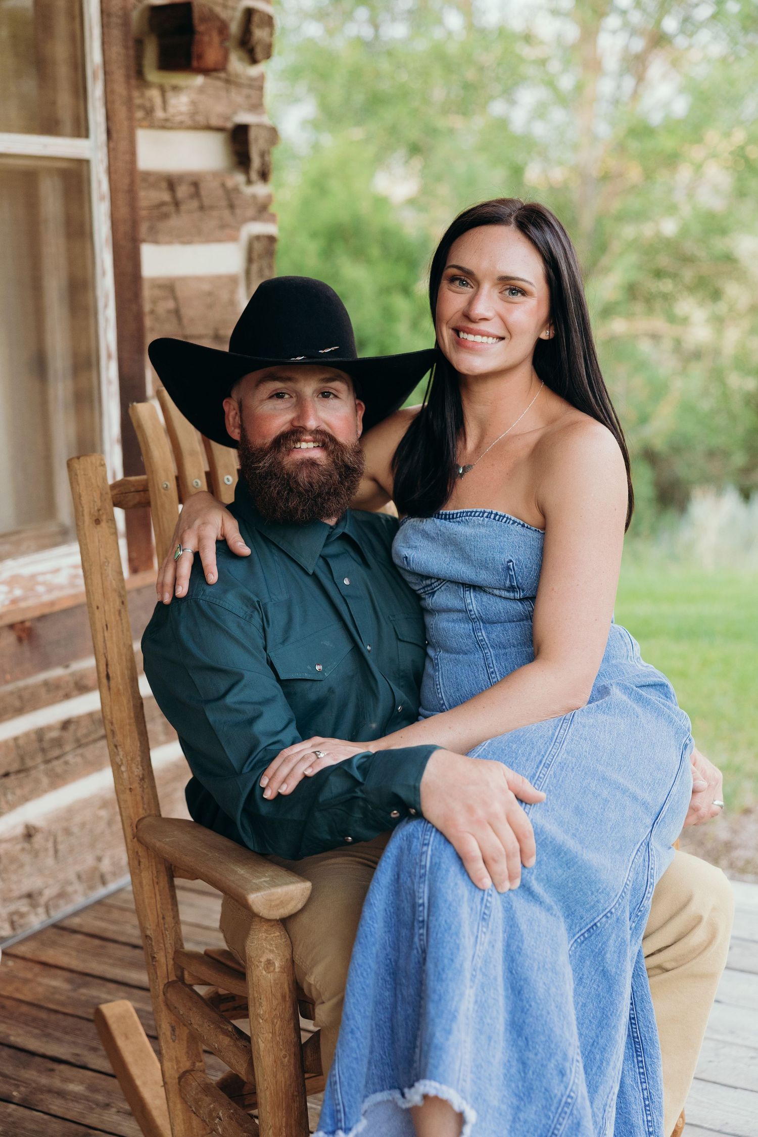 Couple sharing tender moments while sitting on a rustic wooden porch.