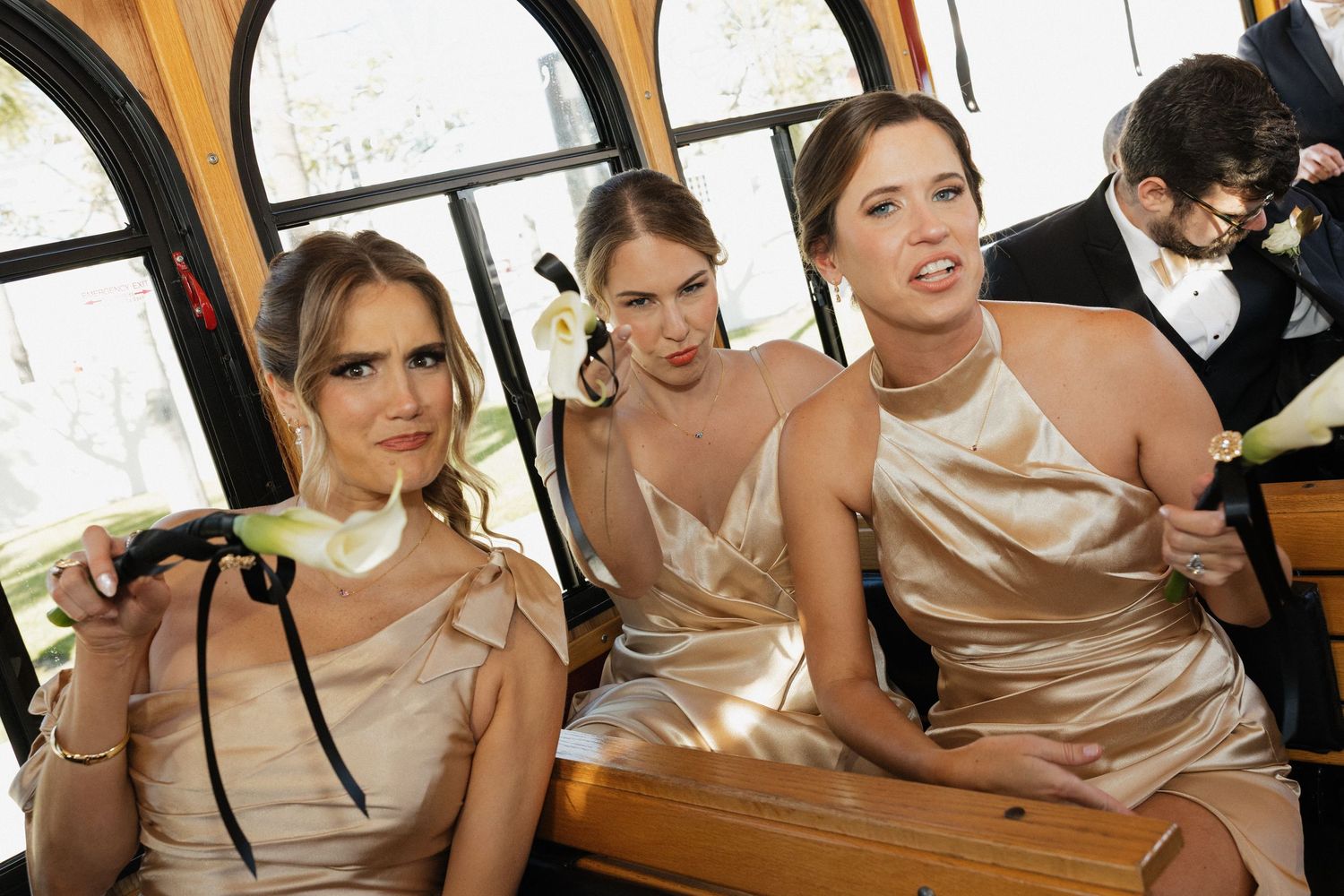 A group of wedding party members in champagne-colored dresses gather together at a celebratory event.