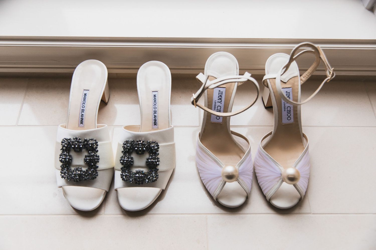 Collection of elegant bridal shoes arranged on a white windowsill.