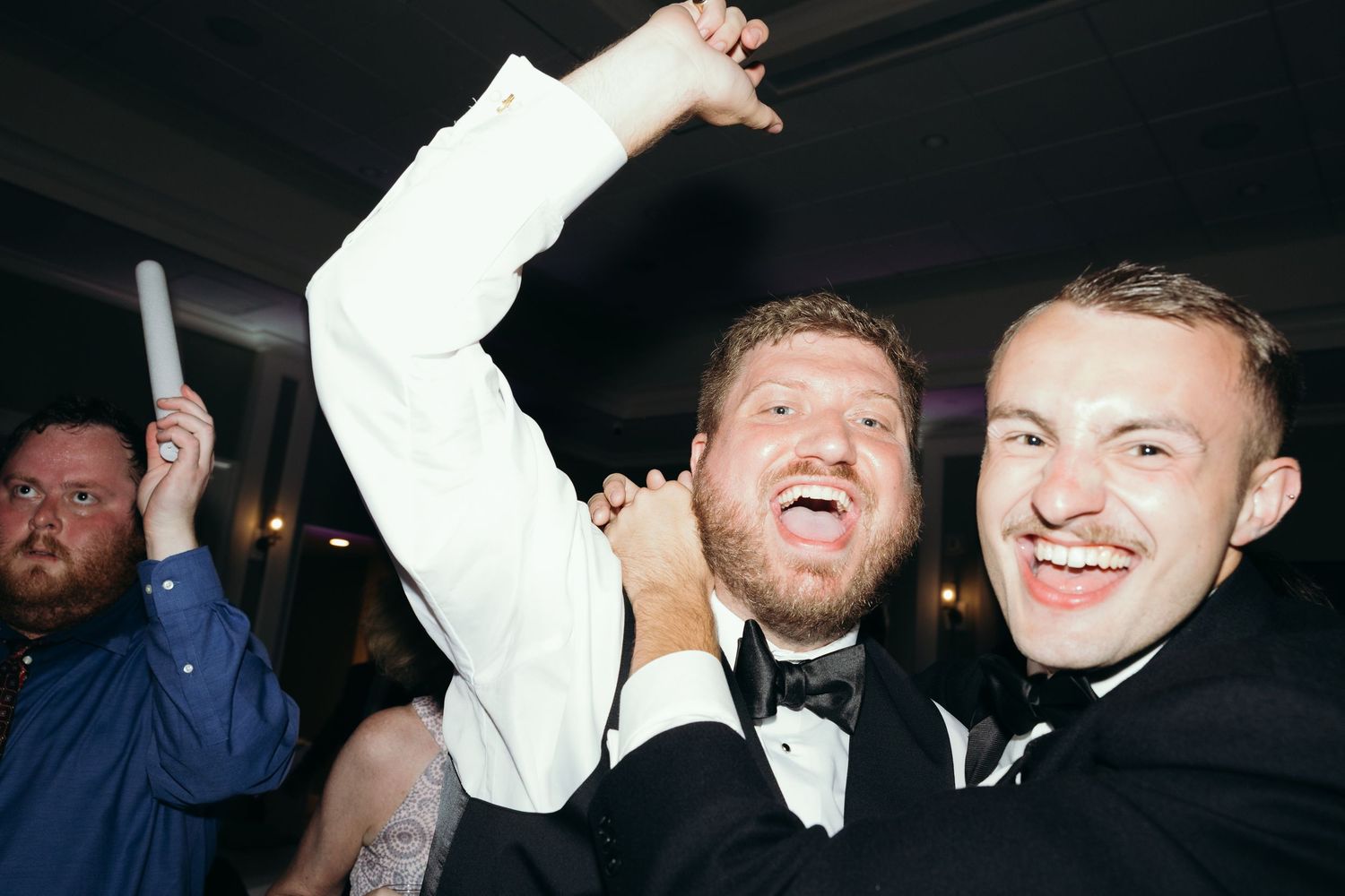 People laughing and celebrating at a lively party reception.