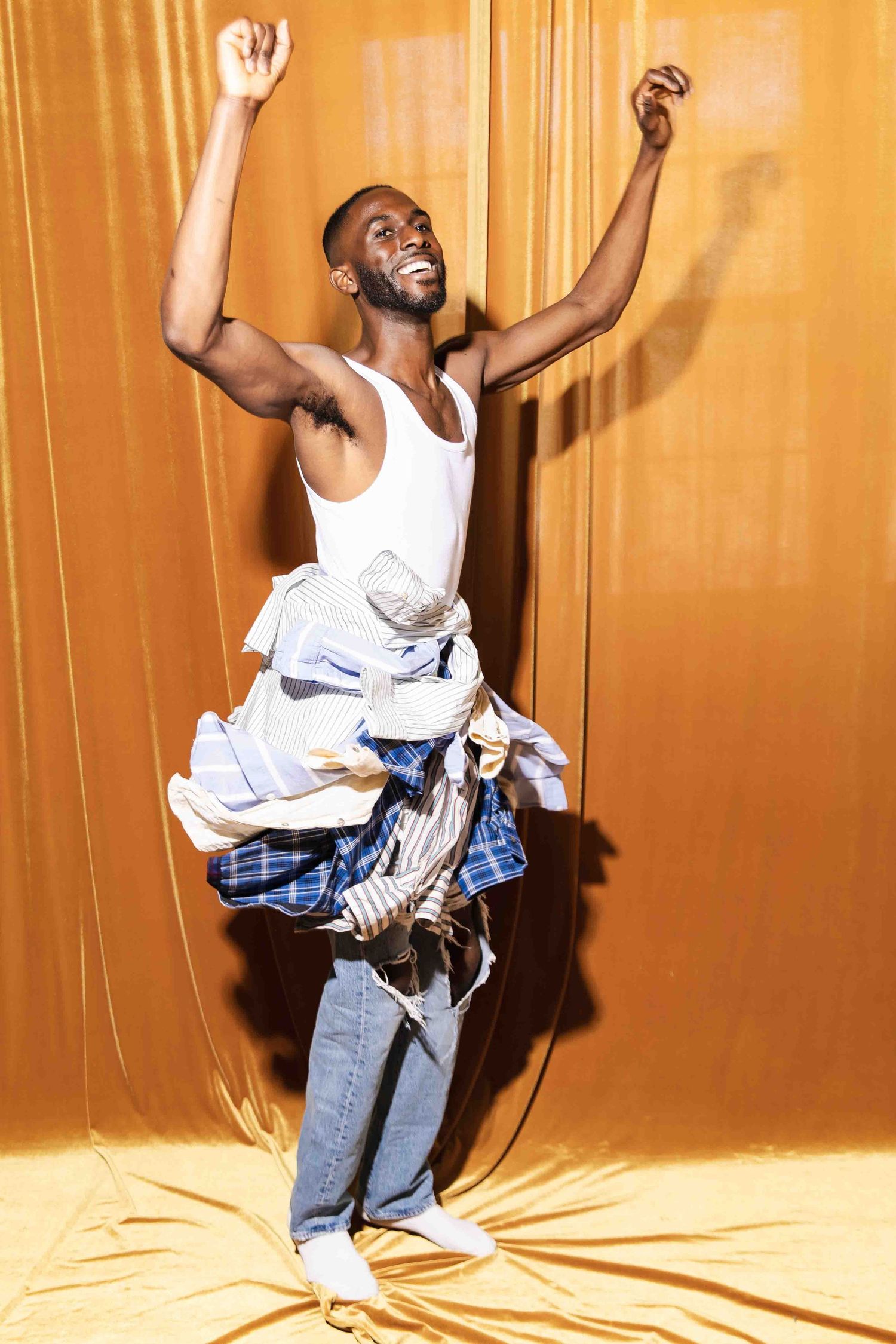 A person in white tank top and plaid shorts dances energetically against an orange backdrop in a four-panel sequence.
