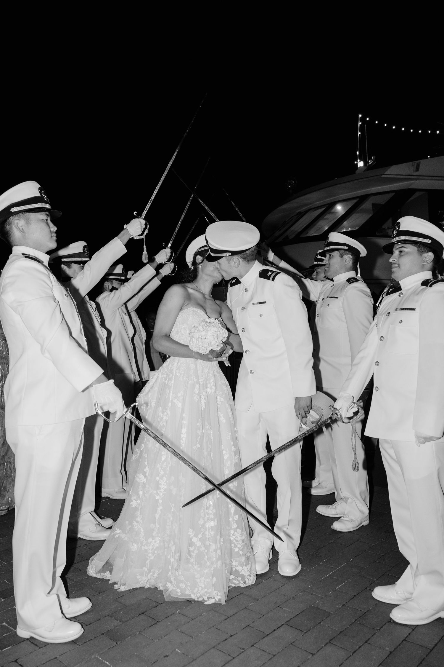 A traditional military sword ceremony line forms at a nighttime wedding.