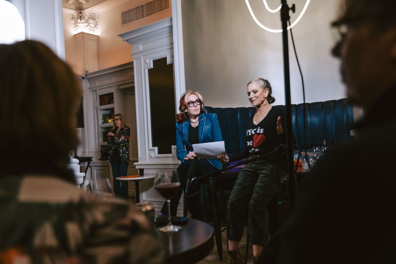 A group of people sit in a dimly lit room at the Algonquin Hotel